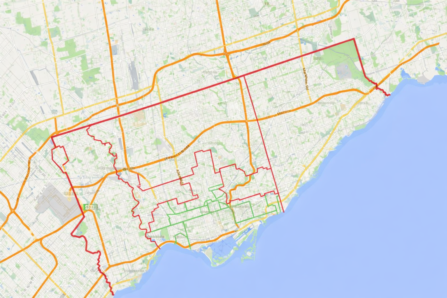 Map of a city with roads highlighted in red, orange, and green, near a large body of water.