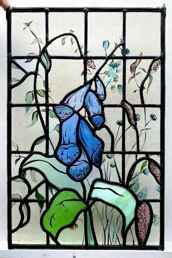 Foxglove design and handpaintd Stained glass window featuring a blue flowering foxglove with green leaves and purple flowers.  skilled glass artist based in london