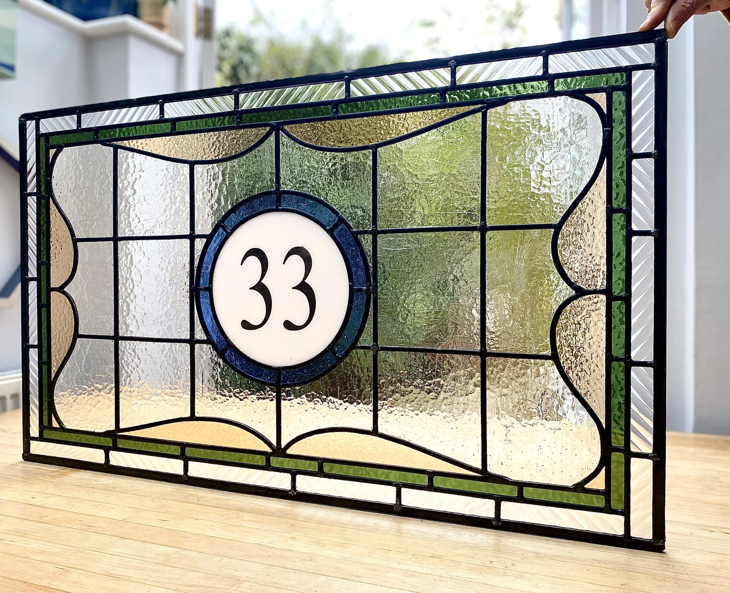Stained glass house number 33 with decorative patterns in blue, green.  By Zoe Henderson.