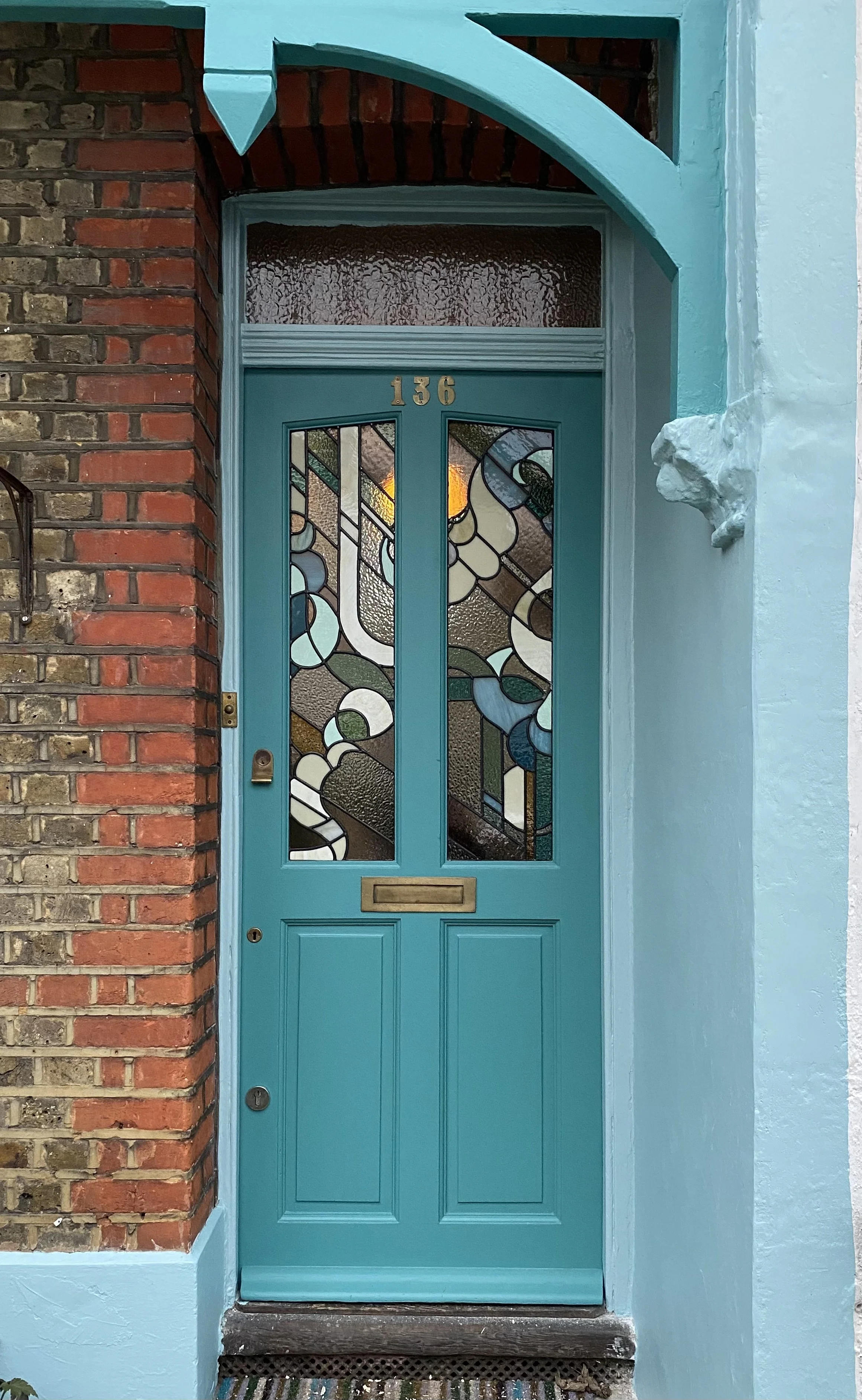 Bright turquoise door with stained glass panels.  Top rated stained glass artist in london