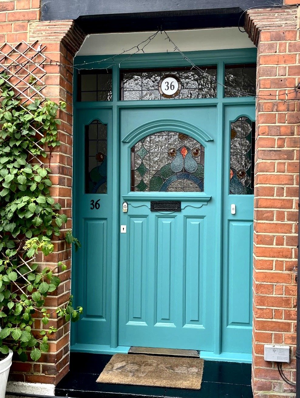 A vibrant turquoise front door with decorative stained glass panels . Top rated stained glass company  Designed and built by Zoe Henderson SE6 London