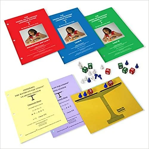 Colorful educational booklets, dice, and game pieces for a learning activity, including red, blue, green, yellow, and purple booklets with images of a girl reading, and game tokens and dice. This image shows a parent Hands-On Equations set.