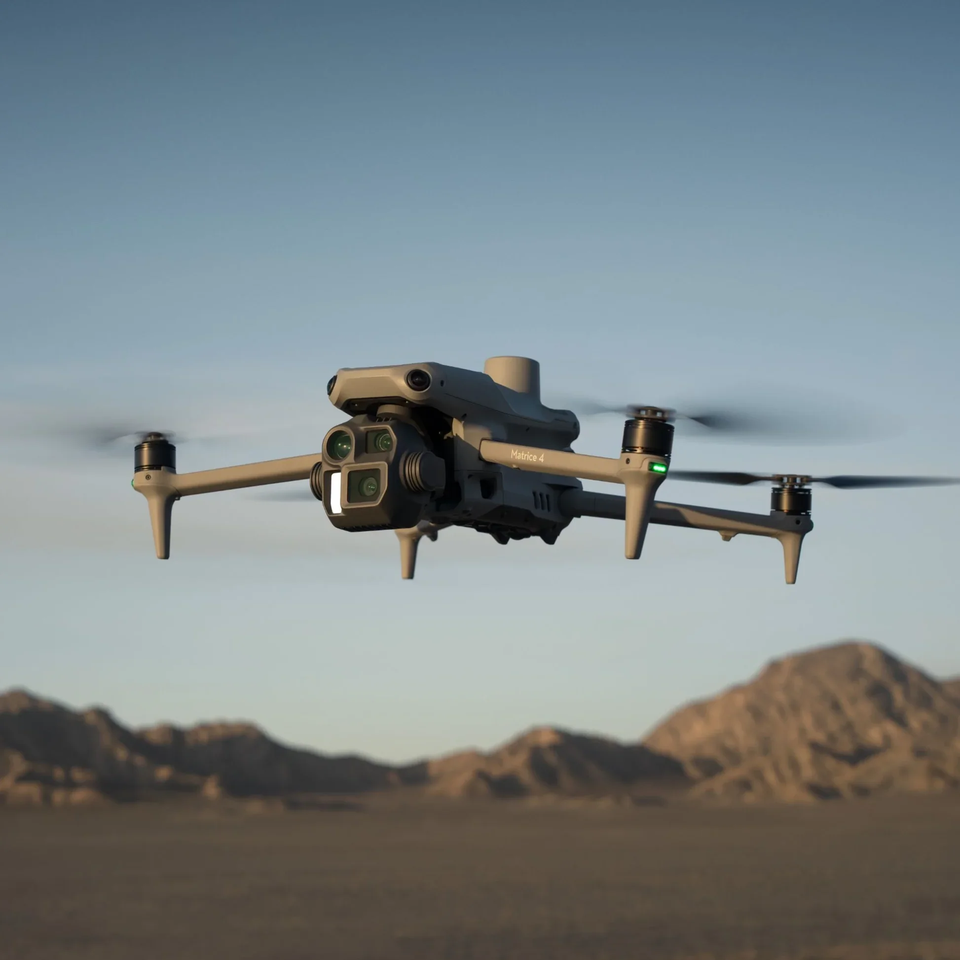 A drone flying over a desert landscape with mountains in the background during daytime.