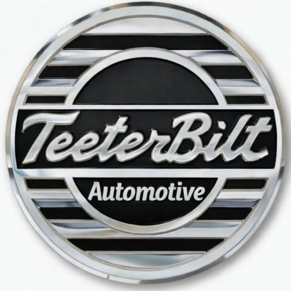 Circular metallic sign with black and white design, displaying the words 'TeeterBilt Automotive' in the center.