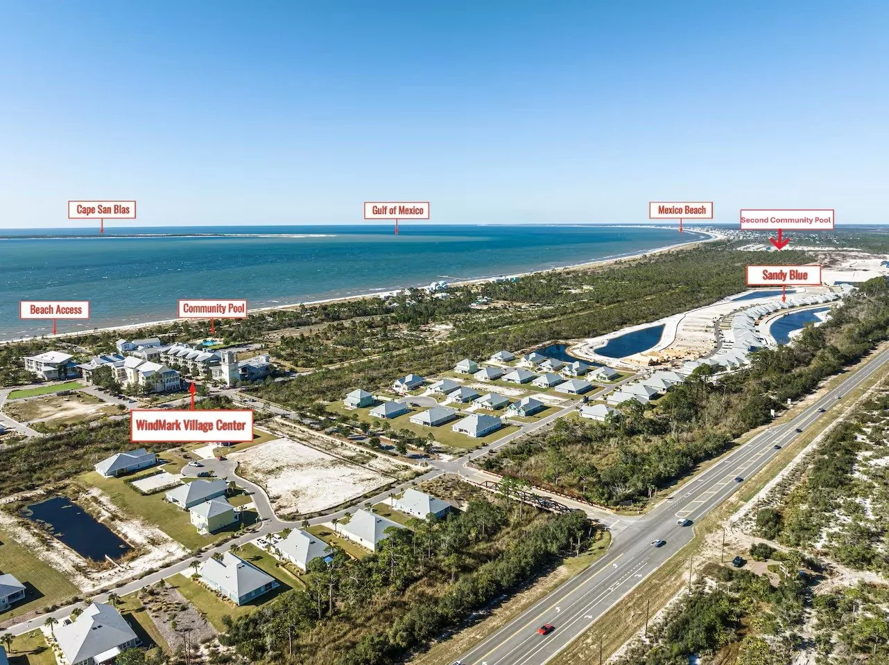 Aerial view of a coastal residential area with labels indicating landmarks: Cape San Blas, Gulf of Mexico, Mexico Beach, Second Community Pool, Sandy Blue, WindMark Village Center, Community Pool, Beach Access, and roads lining the area, with the ocean in the background.