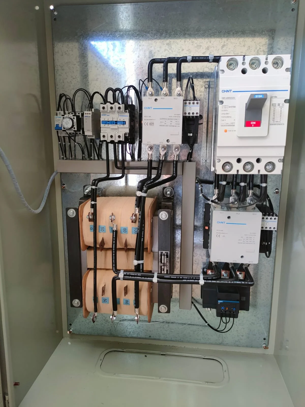 Panel eléctrico con componentes y cables eléctricos.