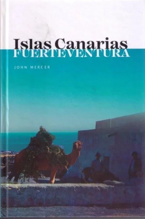 Portada de un libro titulado 'Islas Canarias Fuerteventura' con autor John Mercer. La portada muestra una imagen de una cabra, un muro y dos personas en un entorno costero en la isla de Fuerteventura.