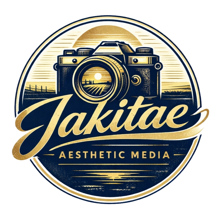 A circular logo for 'Jakite Aesthetic Media' featuring a vintage camera with a sunset and landscape scene reflected in the lens, and the text 'Jakite' in cursive and 'Aesthetic Media' below.