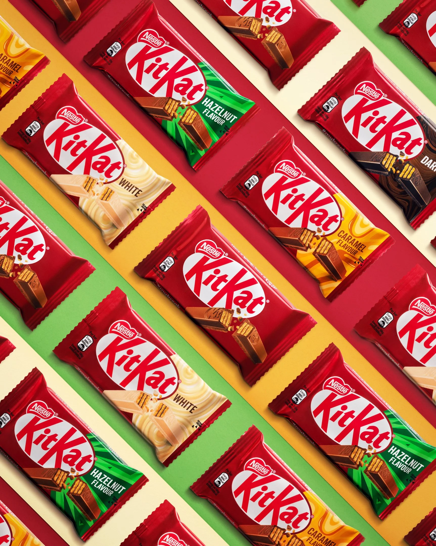 Multiple Nestle KitKat chocolate bars in various flavors, including Original, White, Hazelnut, and Caramel, arranged in rows on colorful backgrounds.