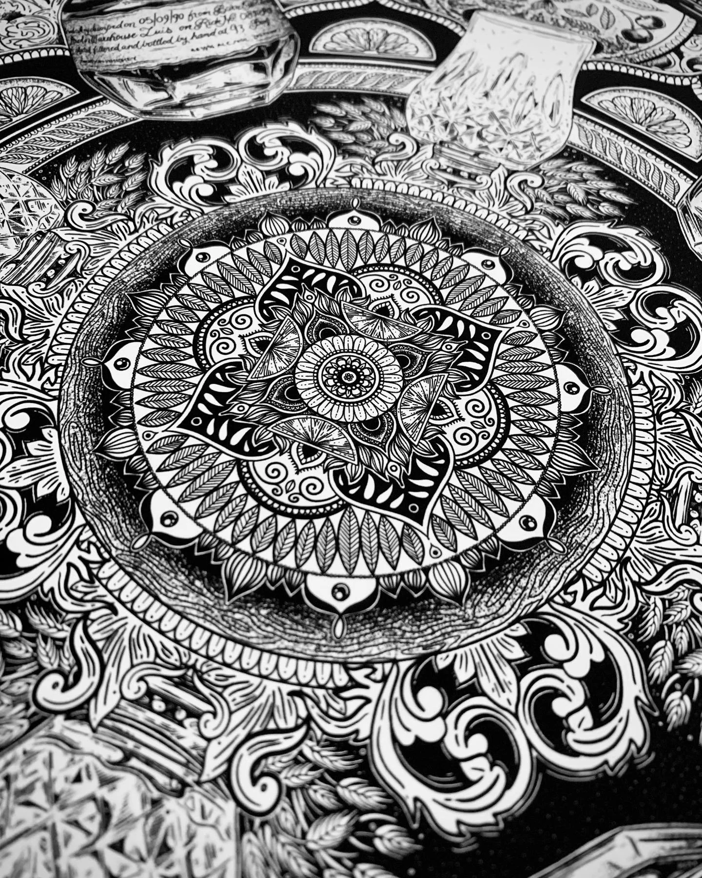 Close-up of an intricate, black and white mandala with detailed patterns, swirls, and geometric shapes.