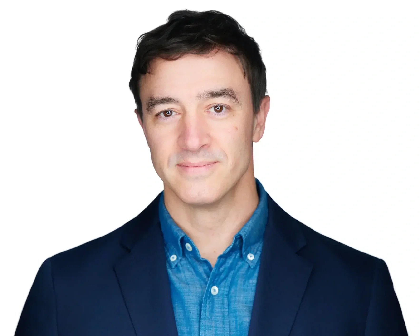 Headshot of a young man with dark hair, wearing a blue button-up shirt and a dark blazer, against a white background.