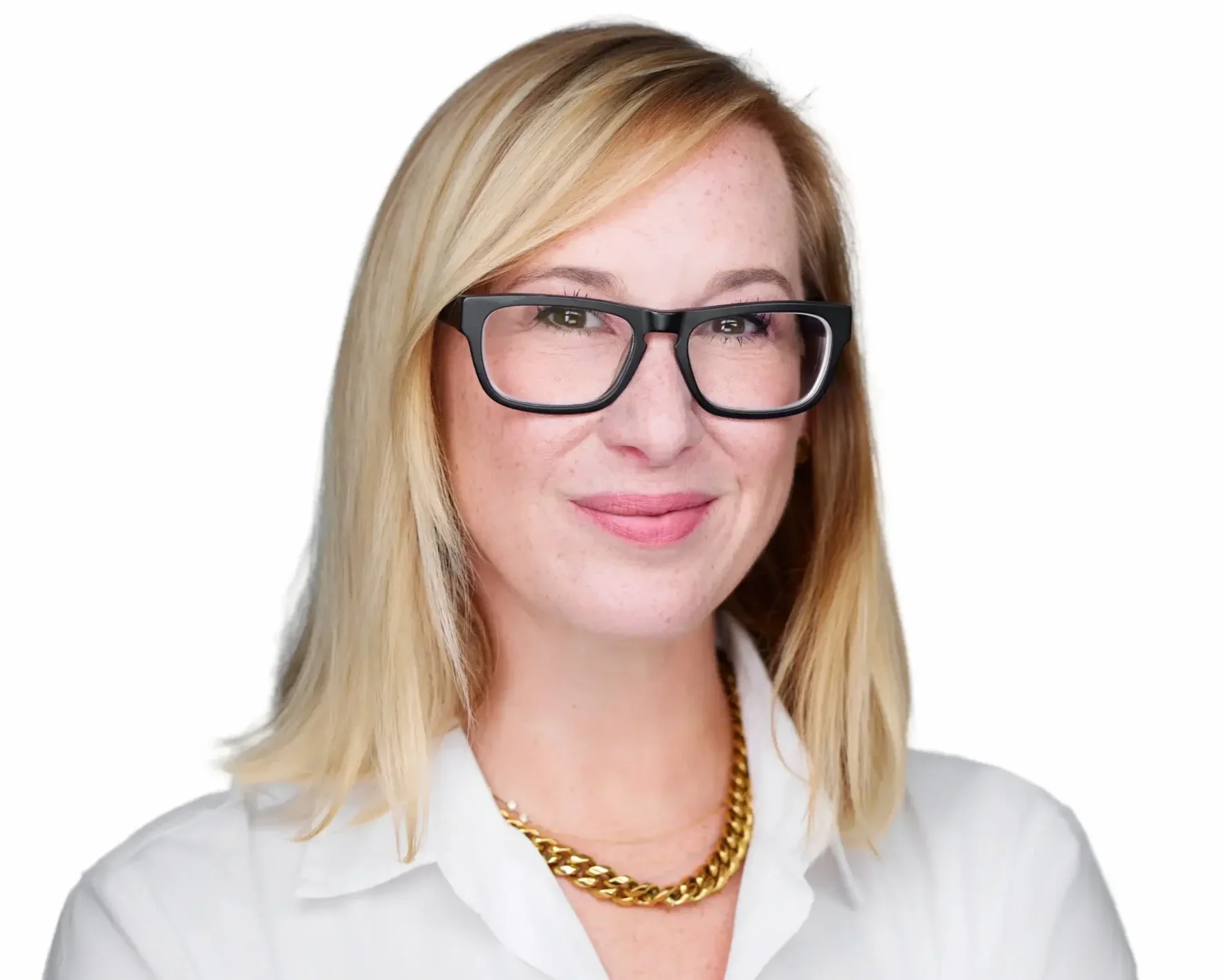 A woman with blonde hair, wearing glasses, a white shirt, and a gold chain necklace, smiling against a white background.