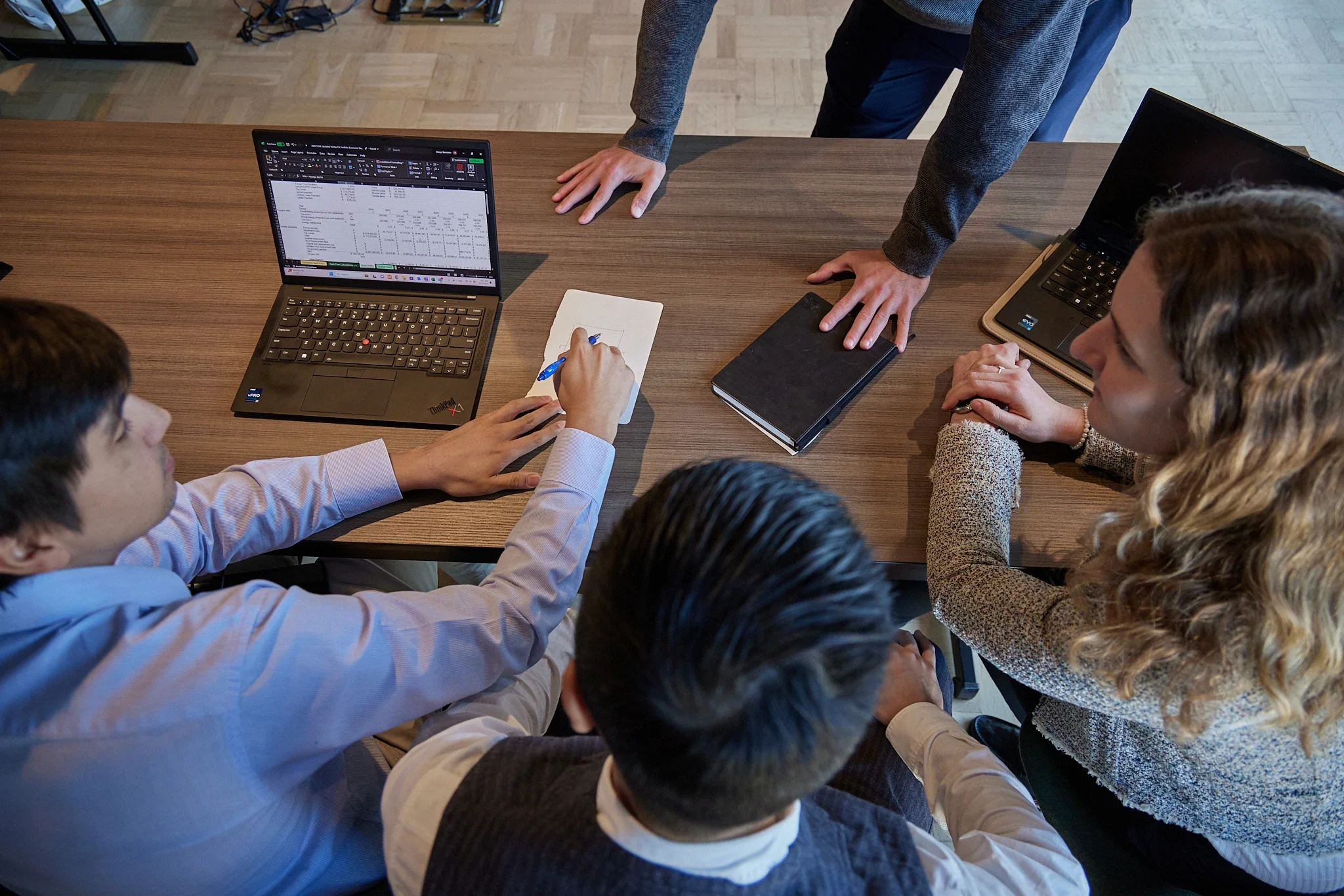 top down photo of employees working together and taking notes