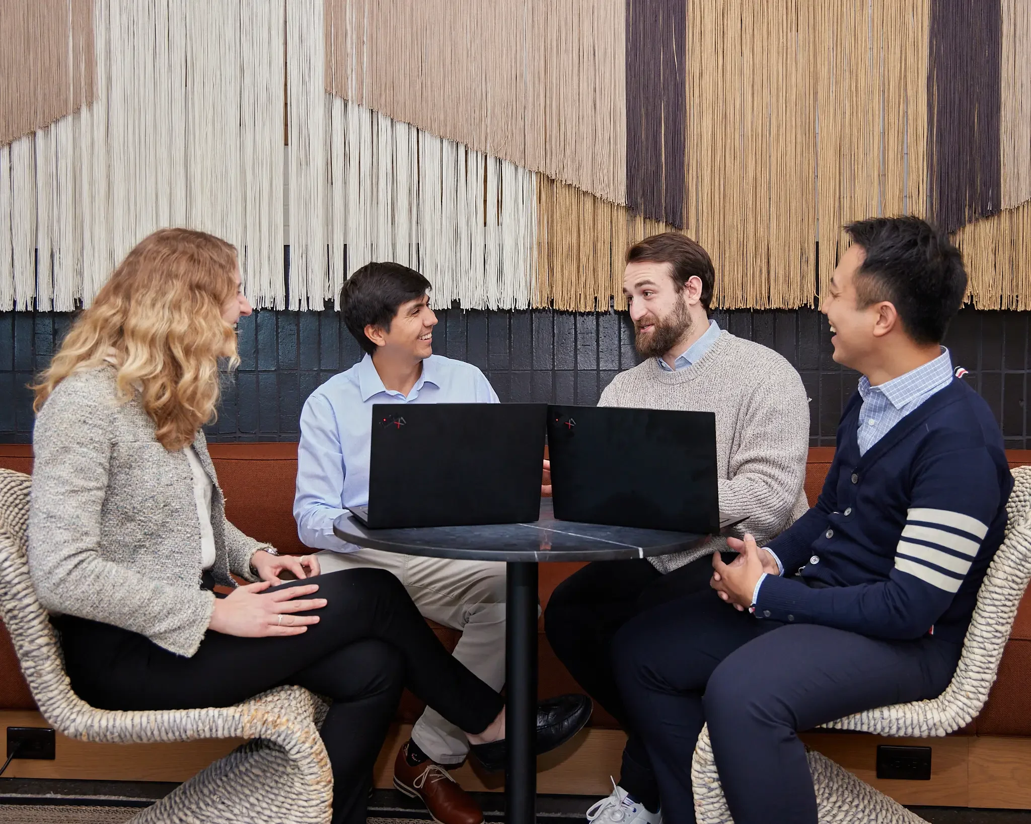 group of employees huddling around computers during company off-site