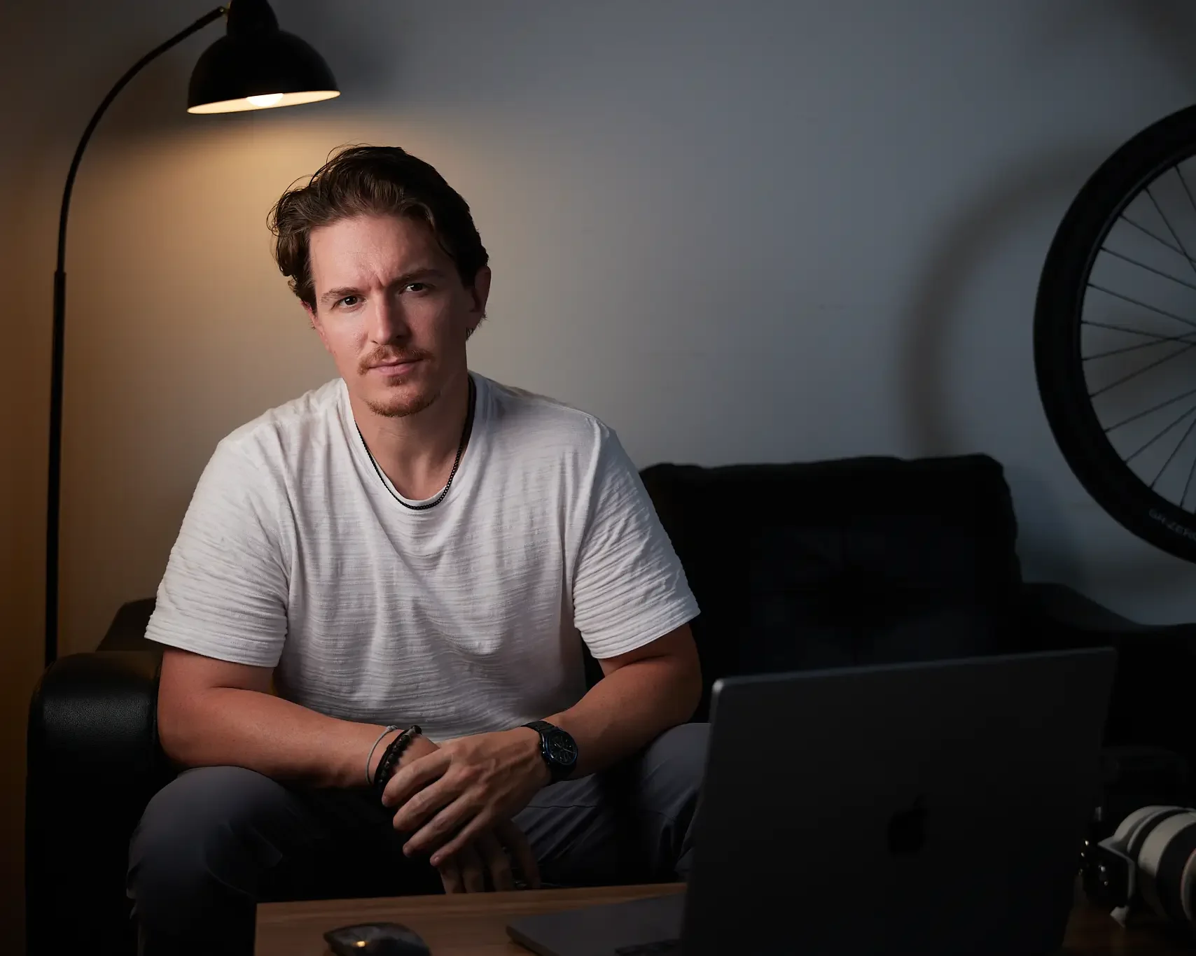a chicago headshot photographer sitting in a living room with a camera and laptop