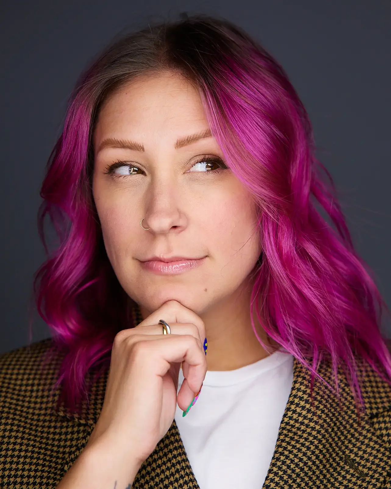 female with pink hair giving the thinking man pose