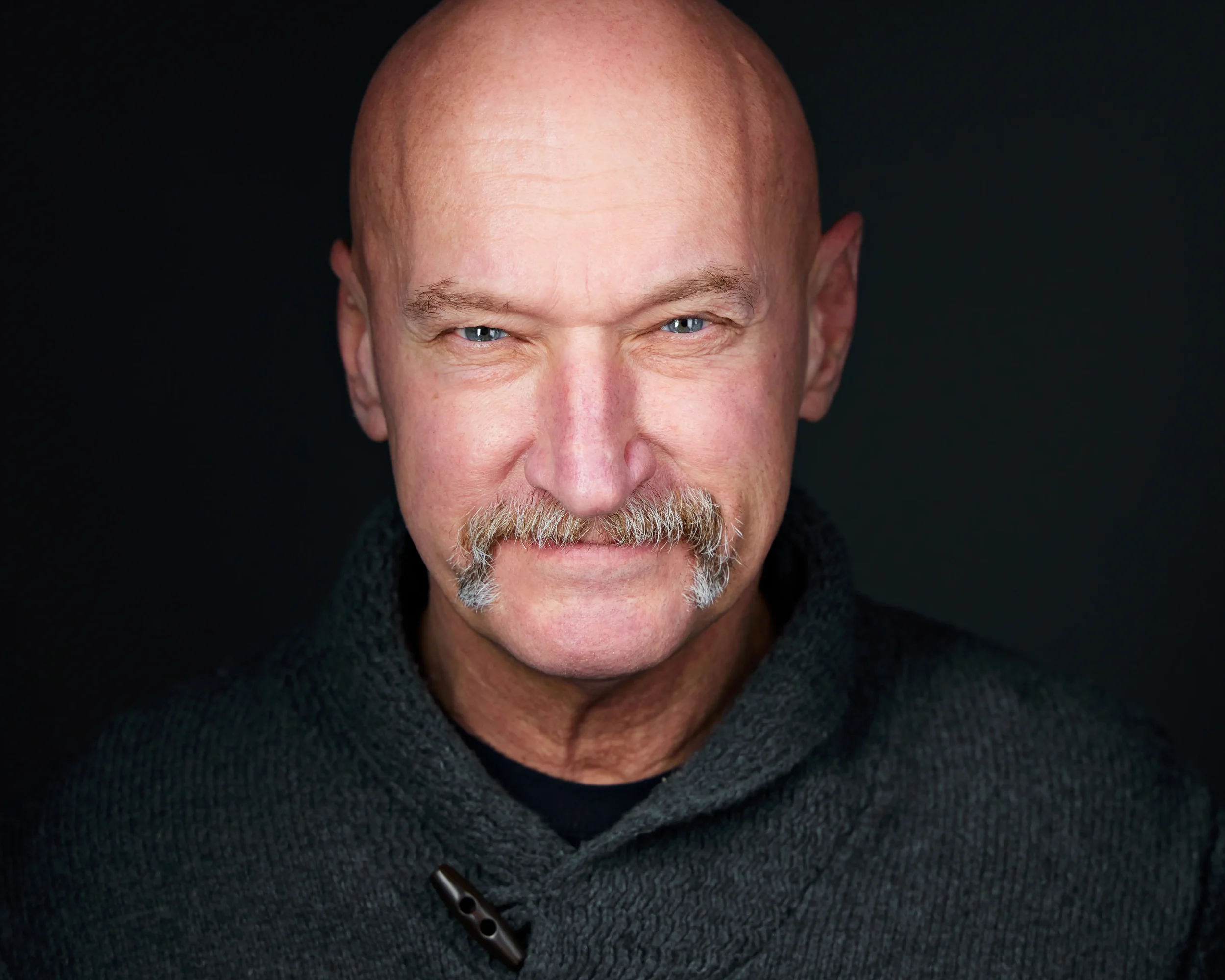 Exec portrait of a man with a mustache in a sweater