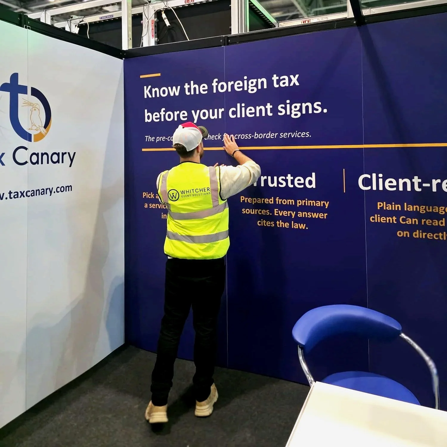 Man applying foamex panels to shell scheme stand
