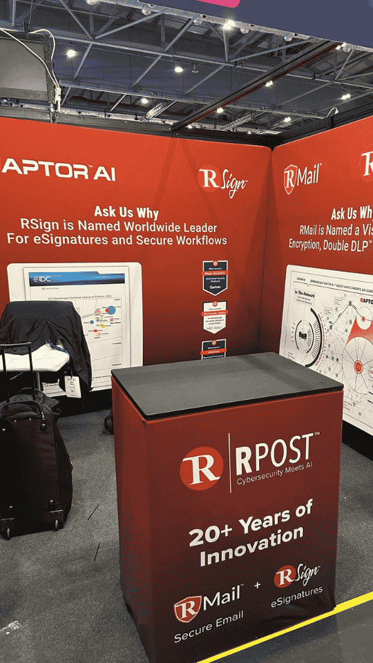 Trade show booth with red backdrop displaying logos for RAPTOR AI, RSign, RMail, and RPost. The booth features a table with branding that highlights 20+ years of innovation in secure email and e-signatures.