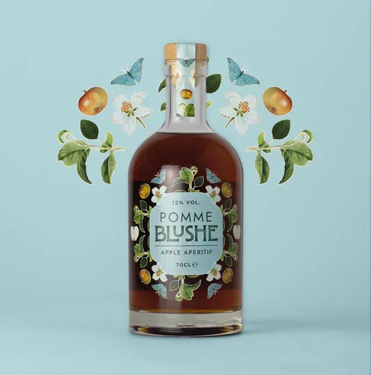 A bottle of Pomme Blush apple aperitif surrounded by illustrations of apples, apple blossoms, green leaves, and blue butterflies on a light blue background.