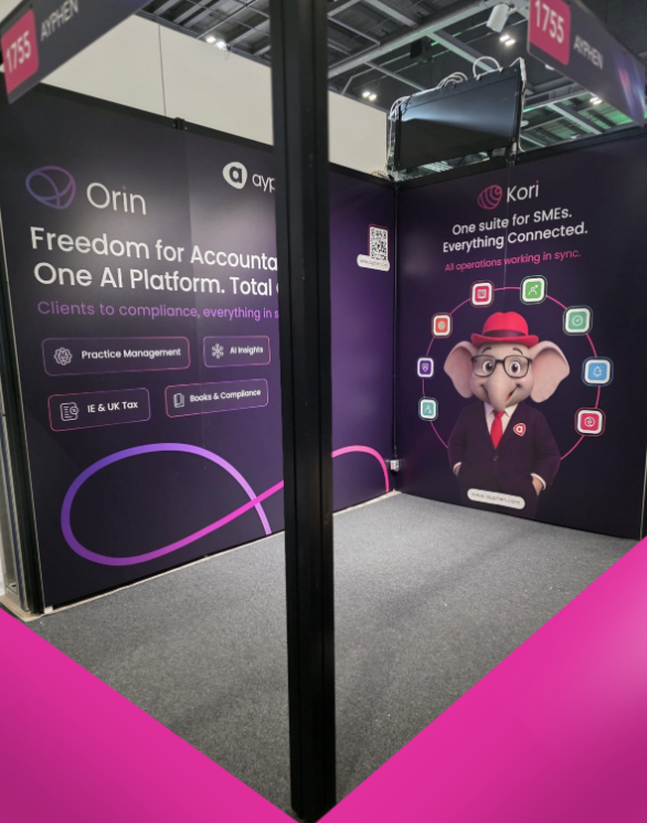 Trade show booth with branding for Orin and Kori, featuring a cartoon elephant in a suit and glasses with a pink hat, at an exhibition hall.