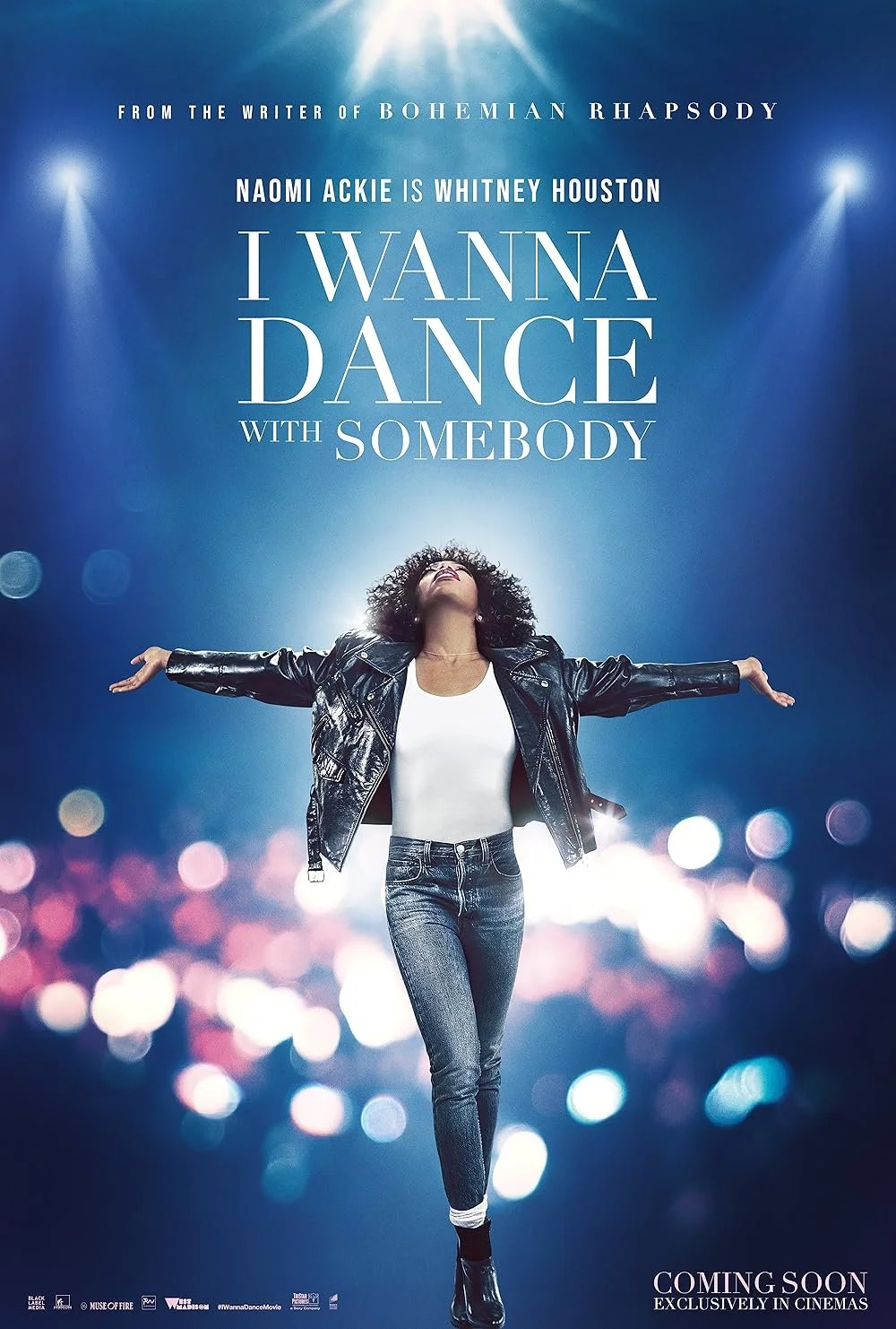 Movie poster for 'I Wanna Dance with Somebody' featuring a woman with curly hair in a leather jacket and jeans, arms stretched out, with a blue and purple bokeh background and a spotlight effect.