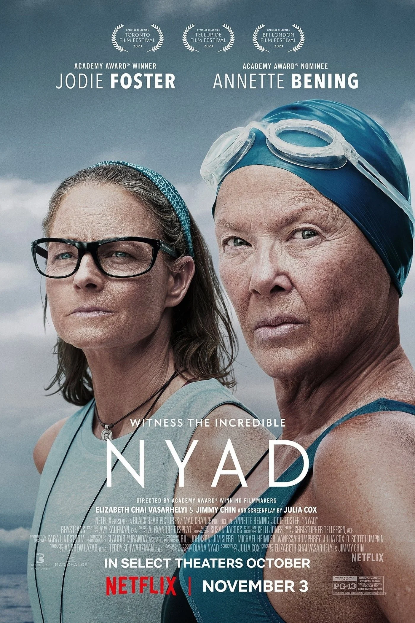 Poster for the documentary film 'Nyad' featuring two women, one with glasses and the other in a swimming cap and goggles, against a cloudy sky background. The poster highlights the film's release date on Netflix, November 3, and awards nominations.