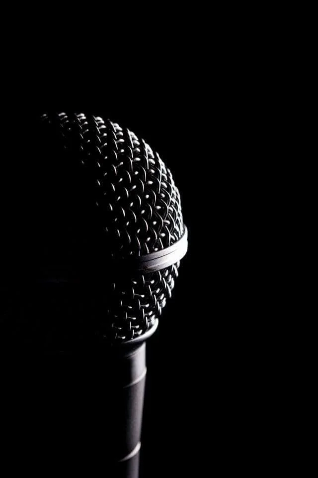 Close-up of a microphone against a dark background.