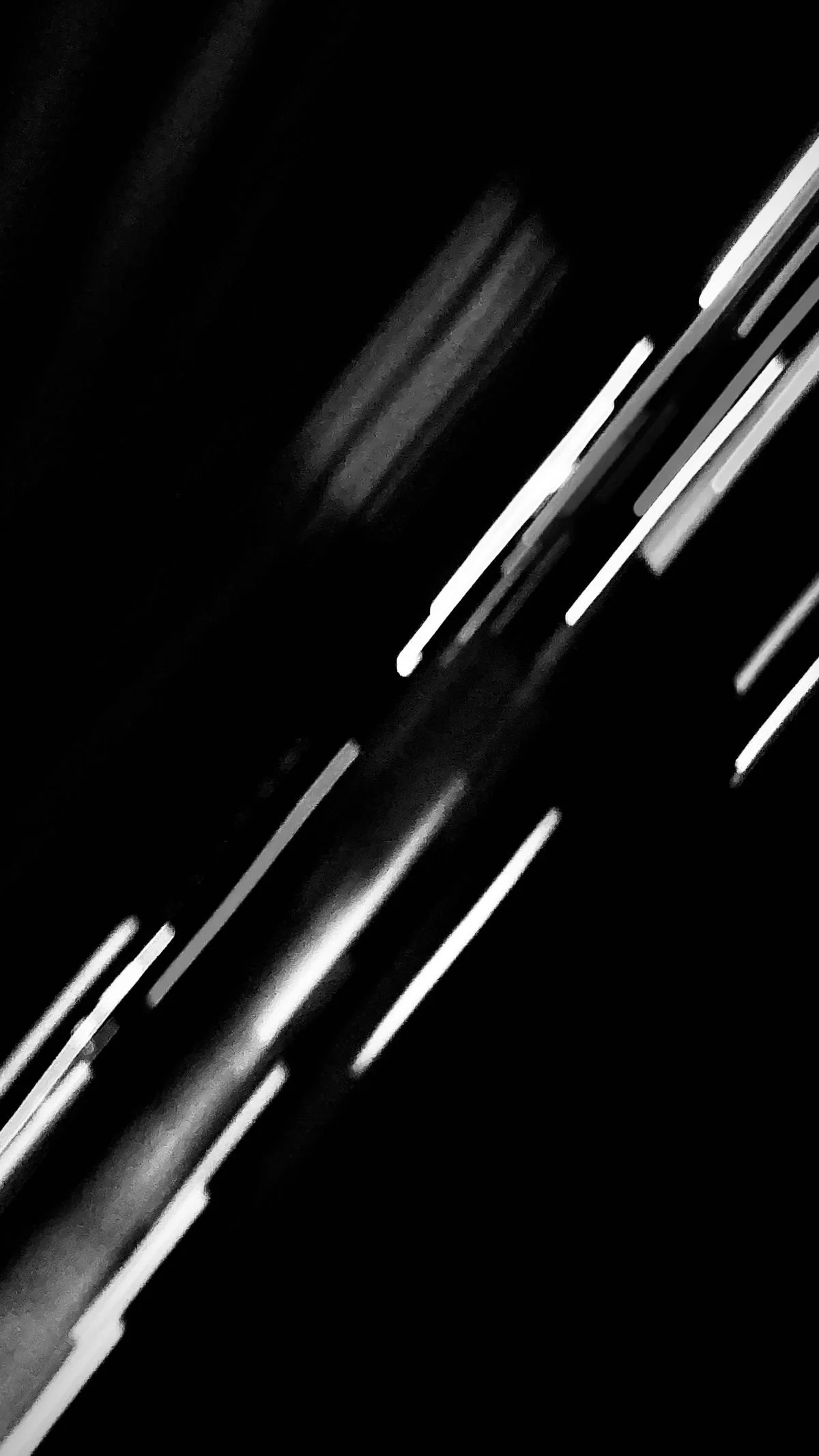 Black and white photo with blurred lines of light, creating an abstract pattern.