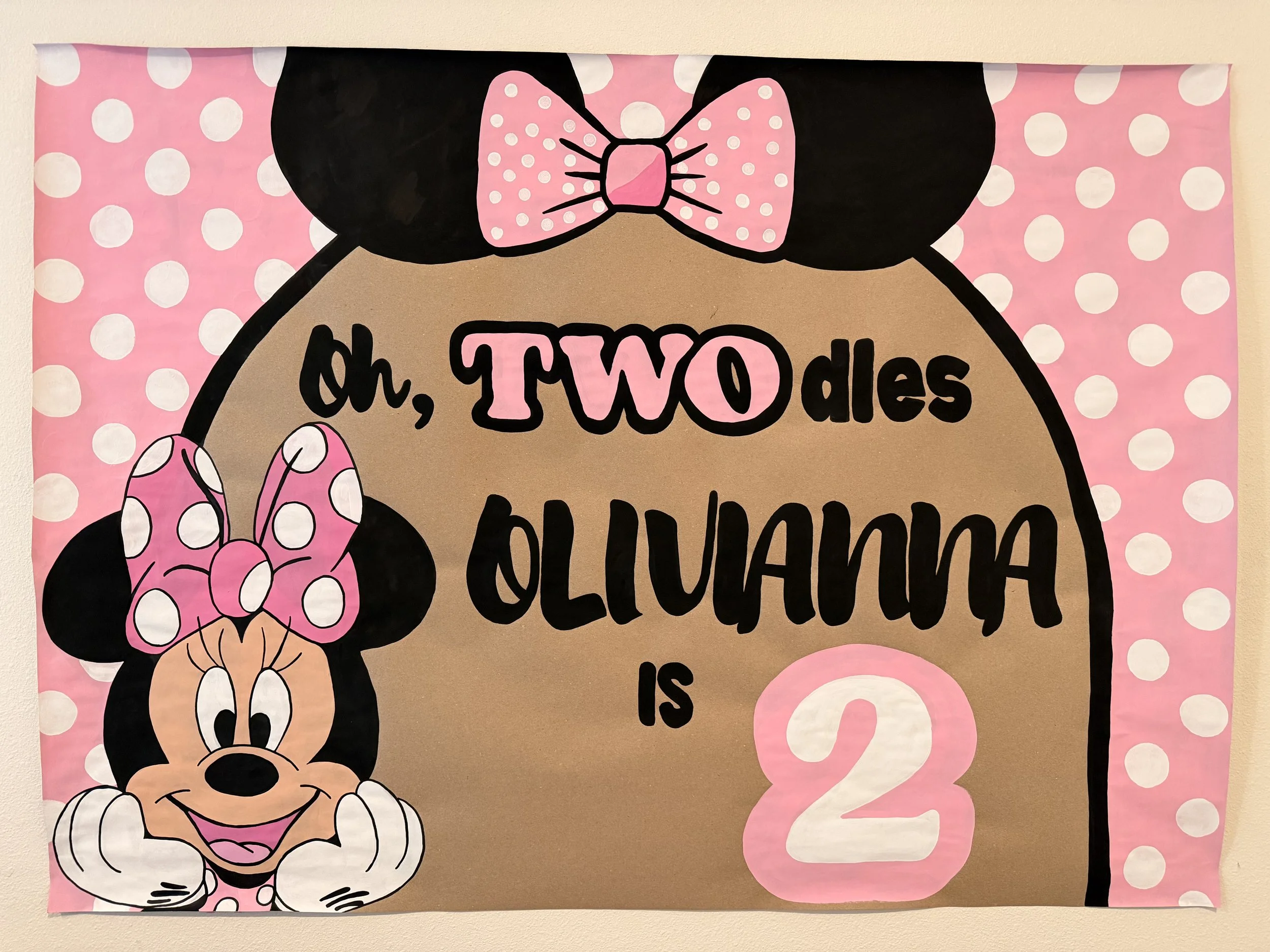 Decorative poster with a cartoon of Minnie Mouse's head, pink polka dot bow, and pink polka dot ears, with the partially visible text 'oh, TWO da... is...'