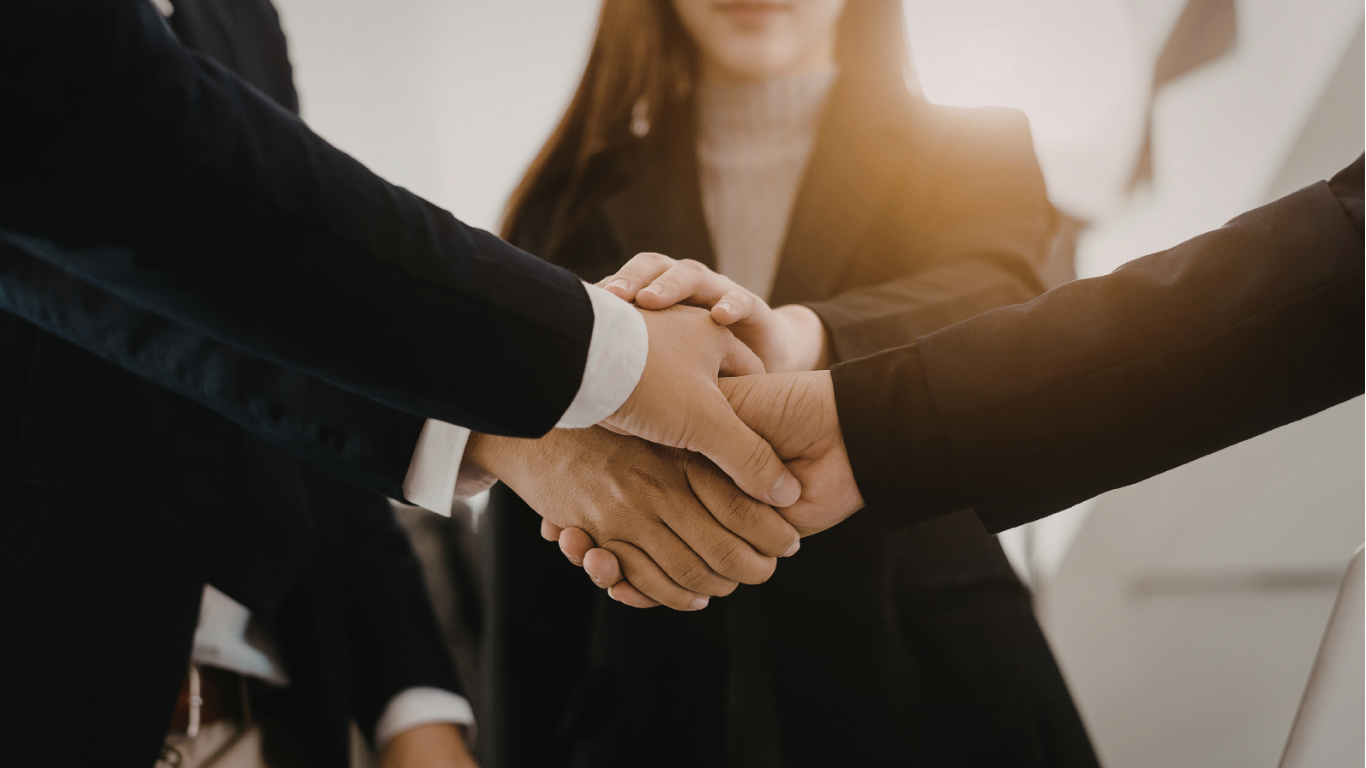 Groupe de personnes se serrant la main, symbolisant un accord ou une collaboration professionnelle.