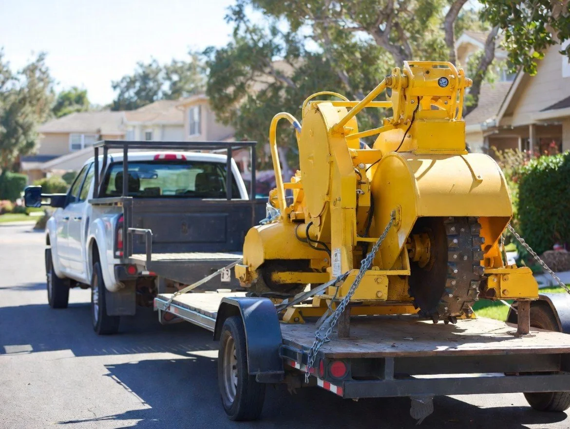 Truck with trailer hauling stump grinder
