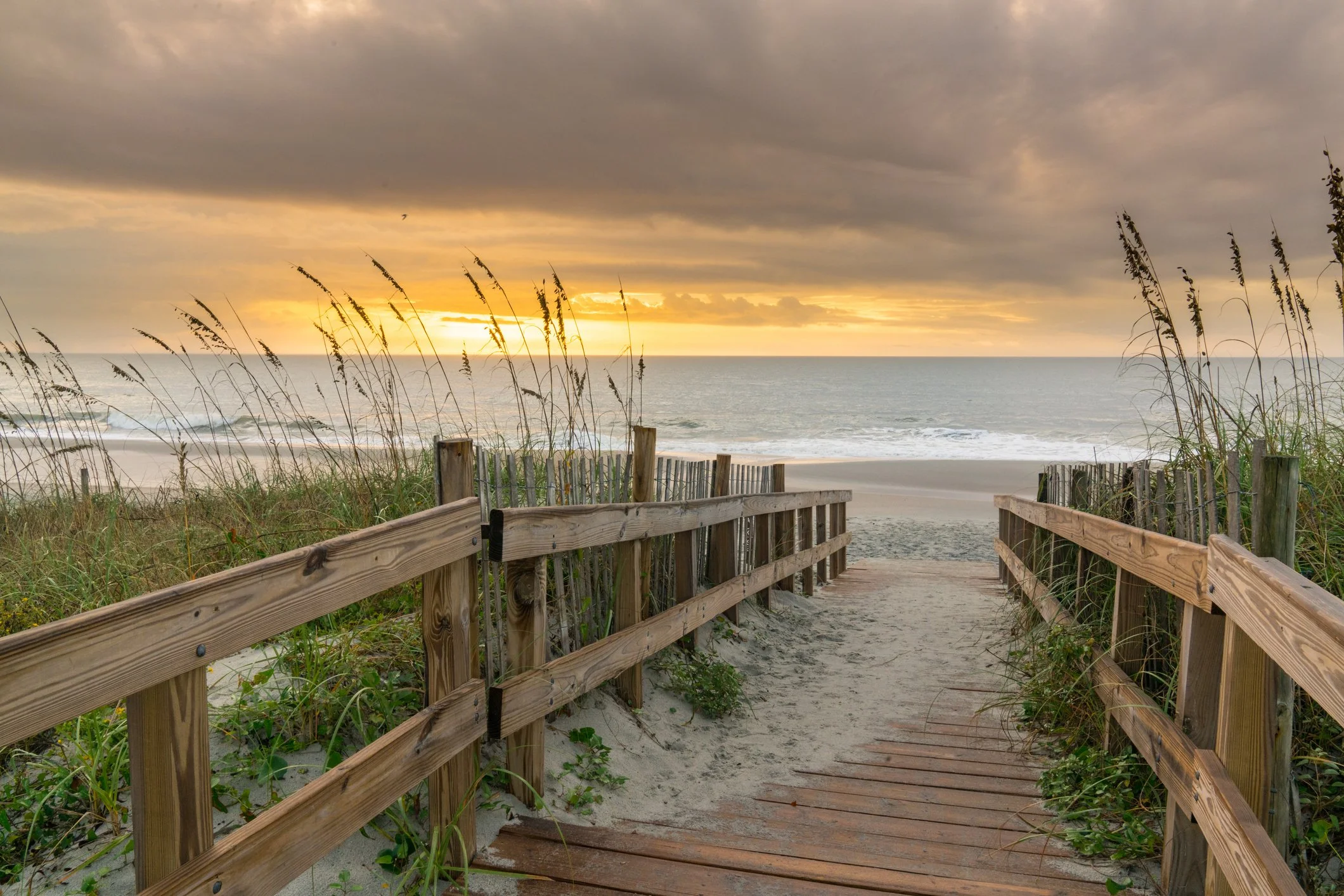 Winding path through sand dunes leading to a peaceful beach, symbolizing the journey toward healing