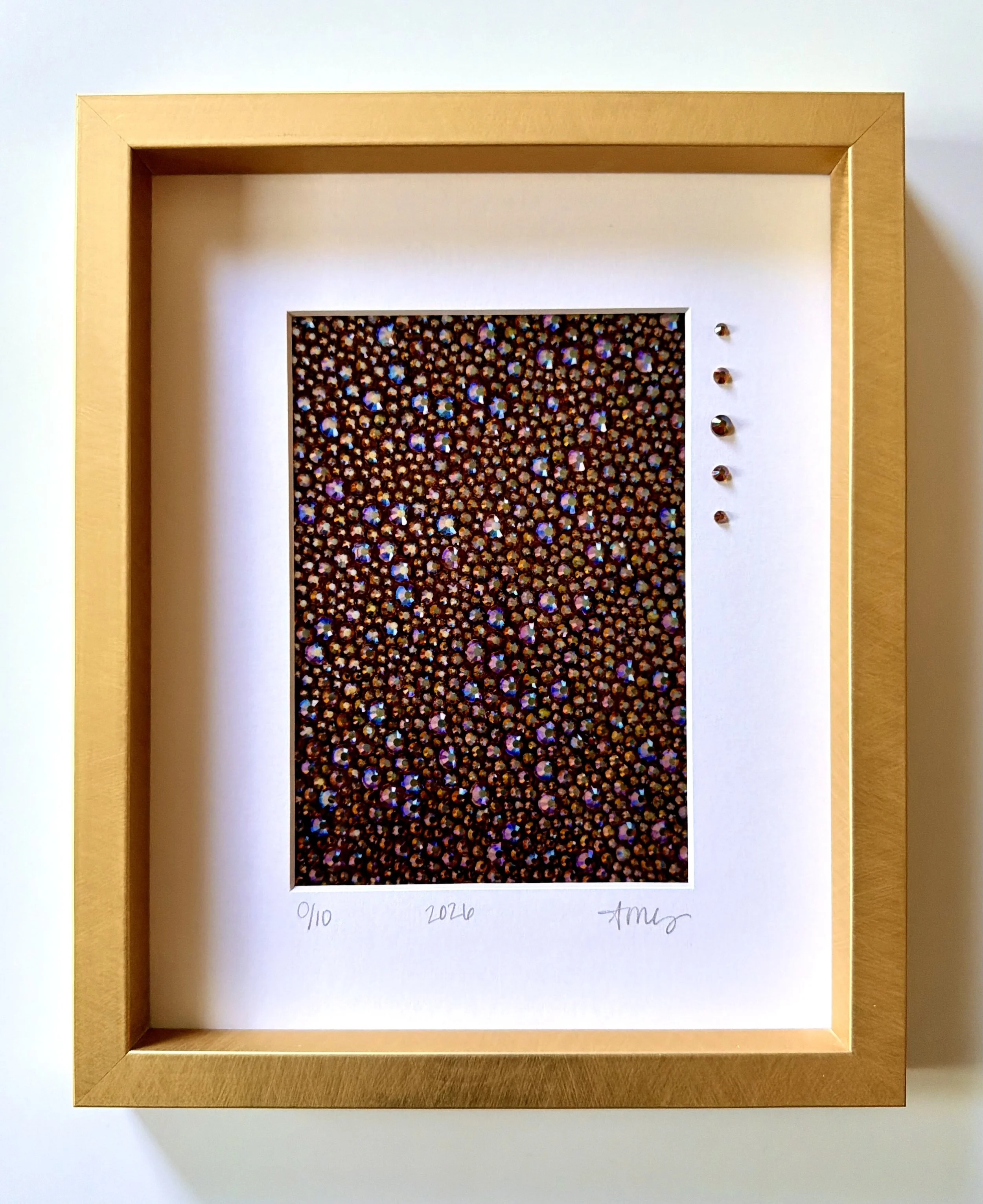 Gluttony [Print] 2026. 5 x 7 in. [matted to 8 x 10 in.] A limited edition macro print of the amber rhinestone panel, featuring five original glass rhinestones hand-placed directly onto the clean white mat.