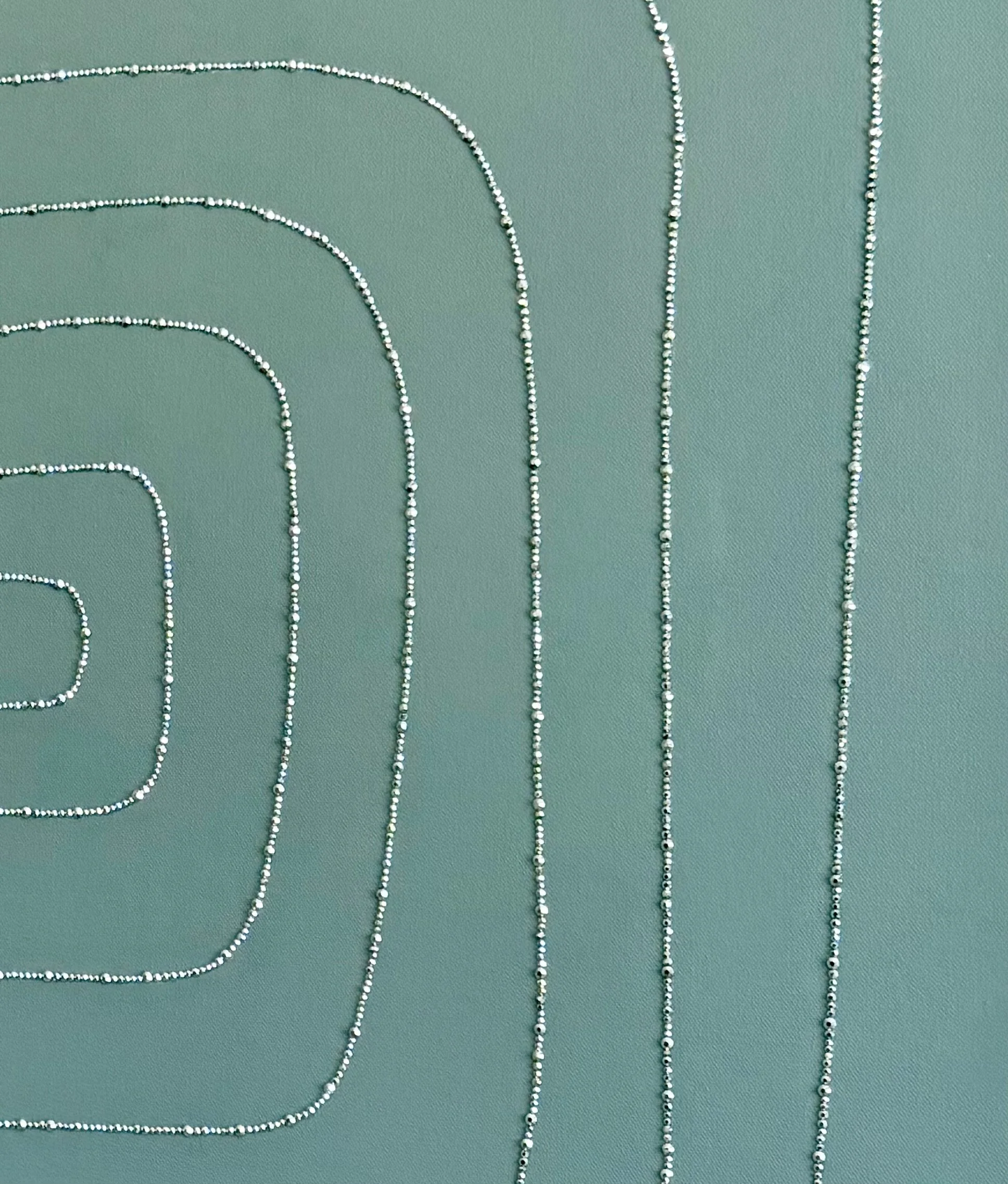Macro detail of Containment (2025). Close-up of silver hematite rhinestones on gray-green acrylic, showing the organic, wobbly square pattern.