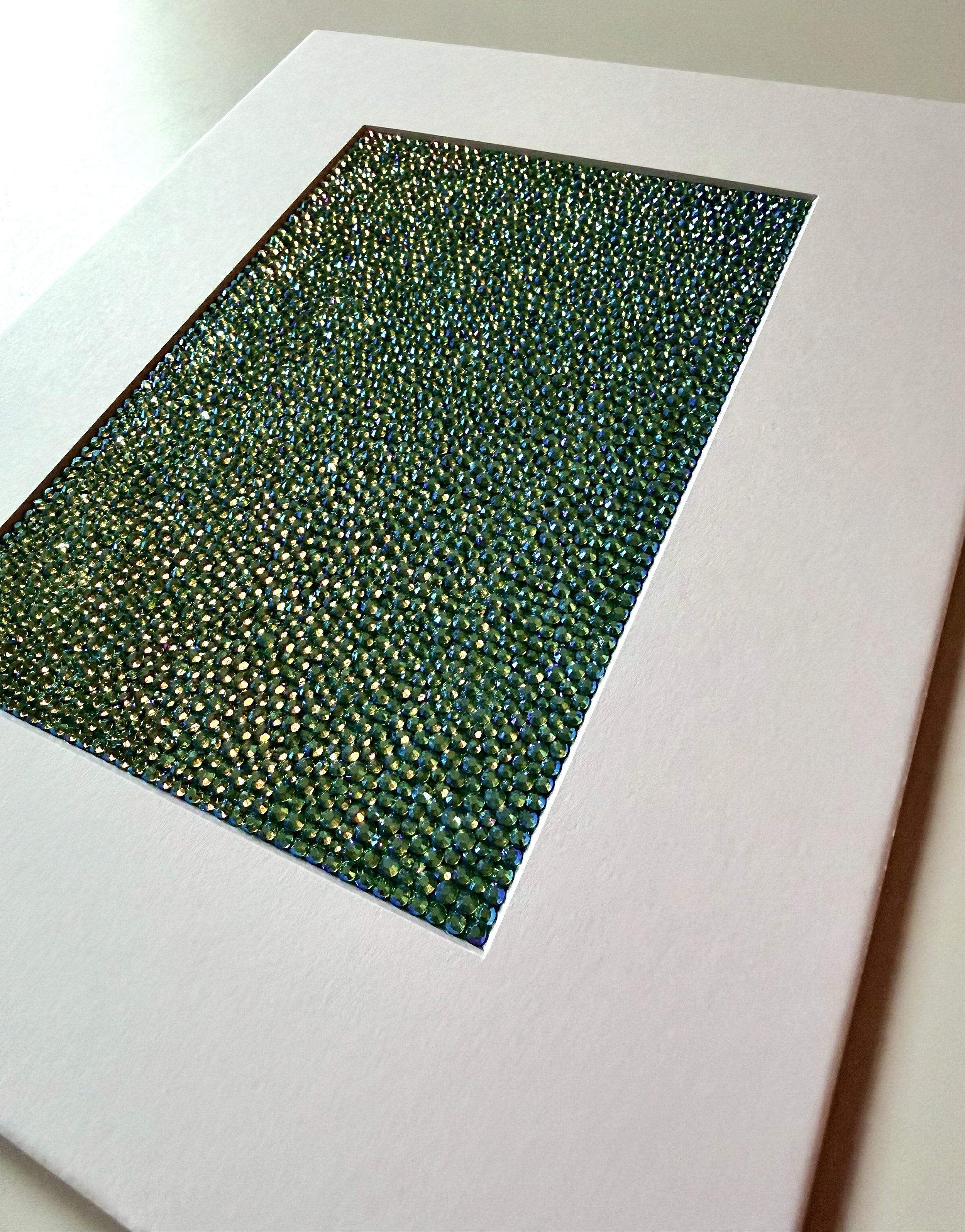 An angled close-up of the "Hollow" paper study, showing the high-relief texture of the green and gold rhinestone field.
