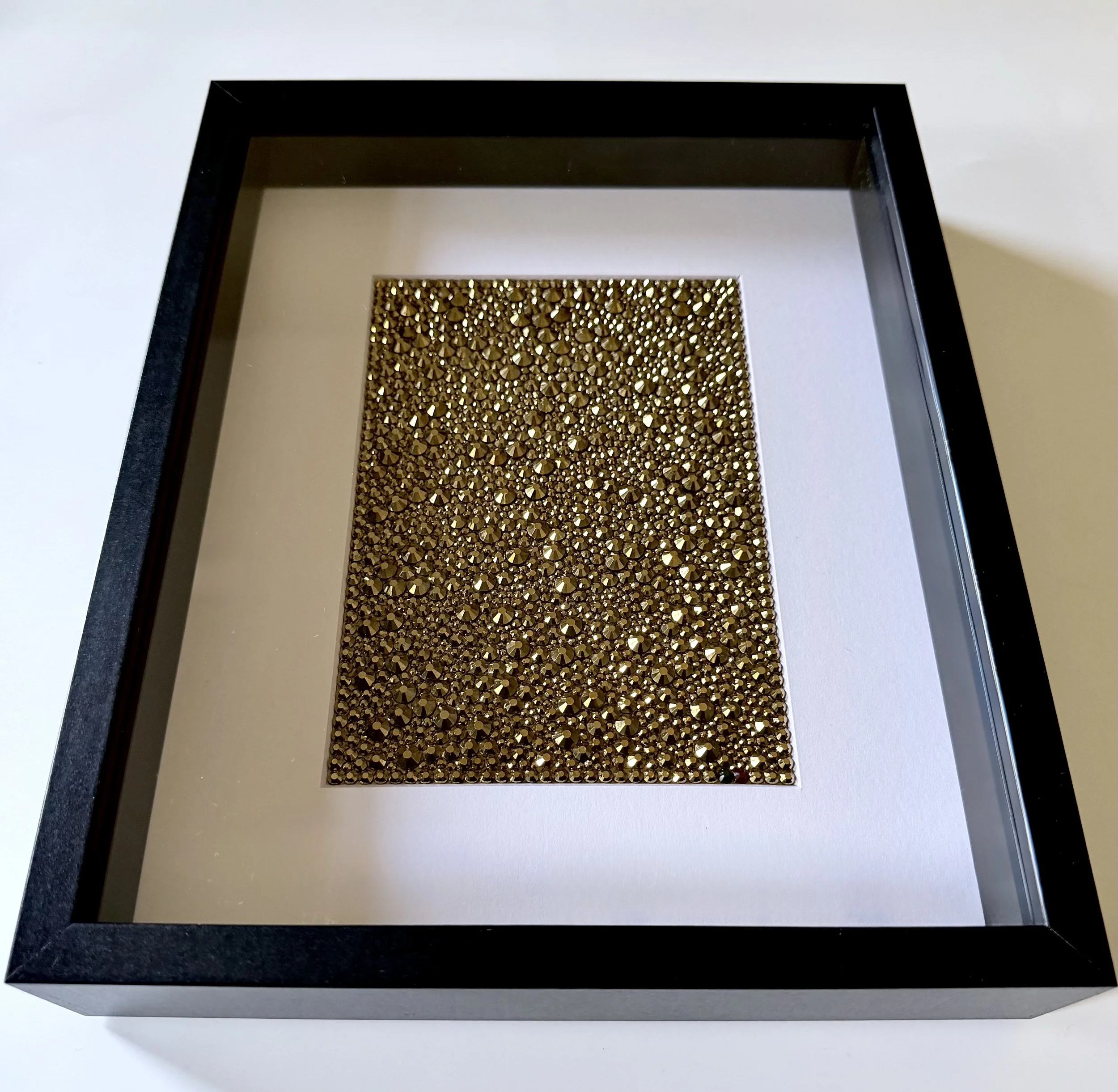 Framed gold rhinestone art piece titled "Resonance."