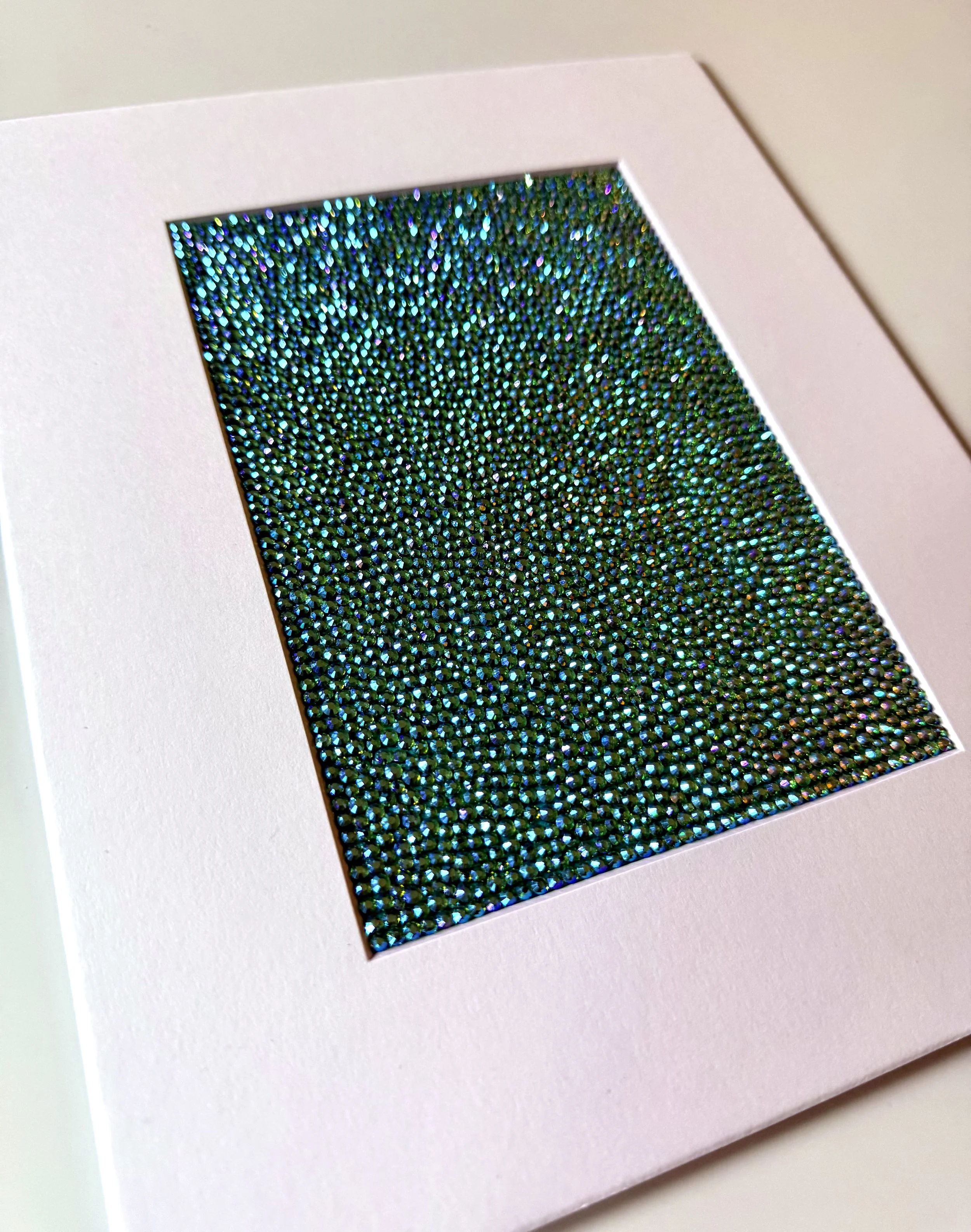 An angled close-up of the "Hollow" paper study, showing the high-relief texture of the green and gold rhinestone field.