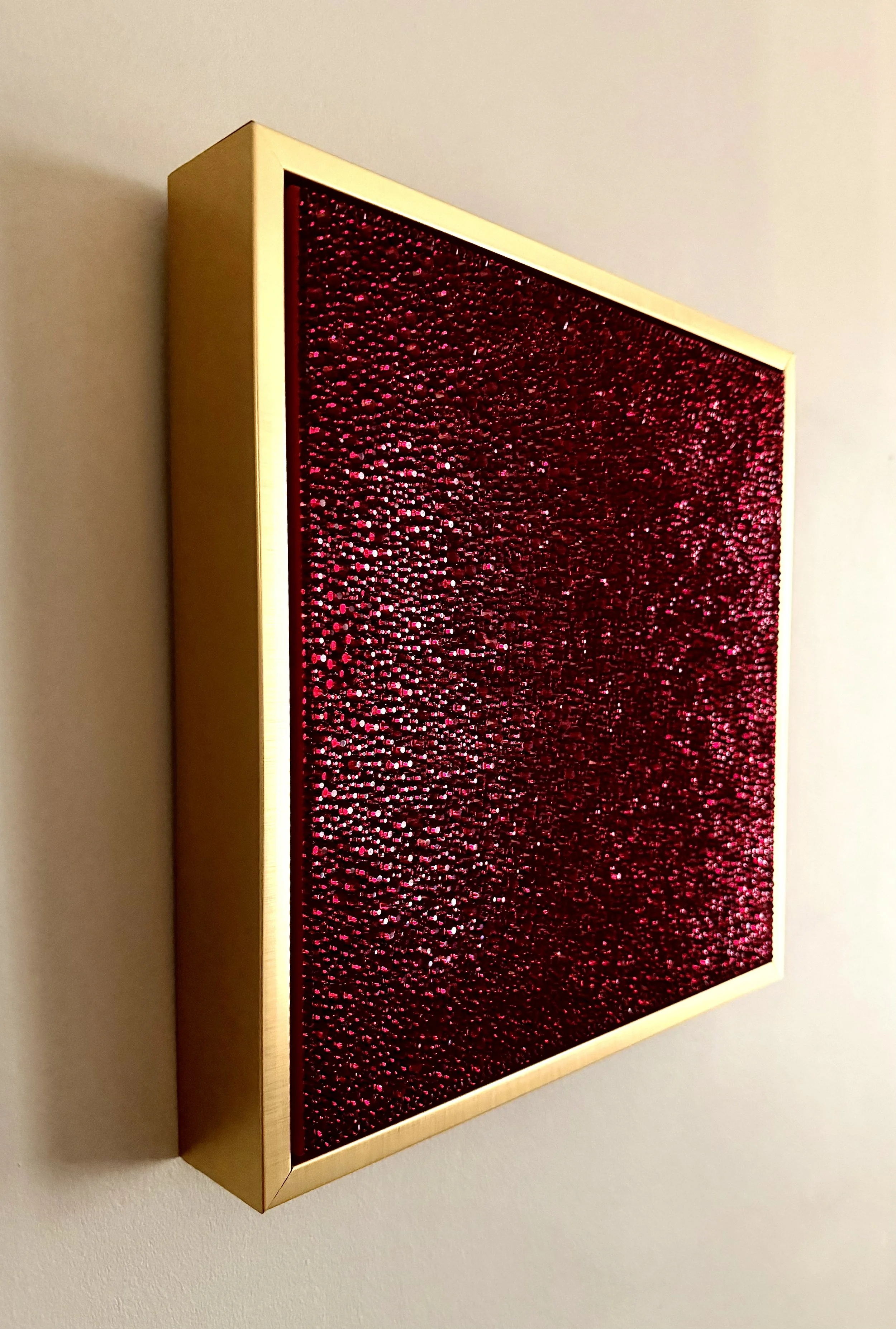 Side view of Wrath (2026) showing the 3D texture of crimson rhinestones and the gold floating frame. Highlights the depth and sculptural profile.