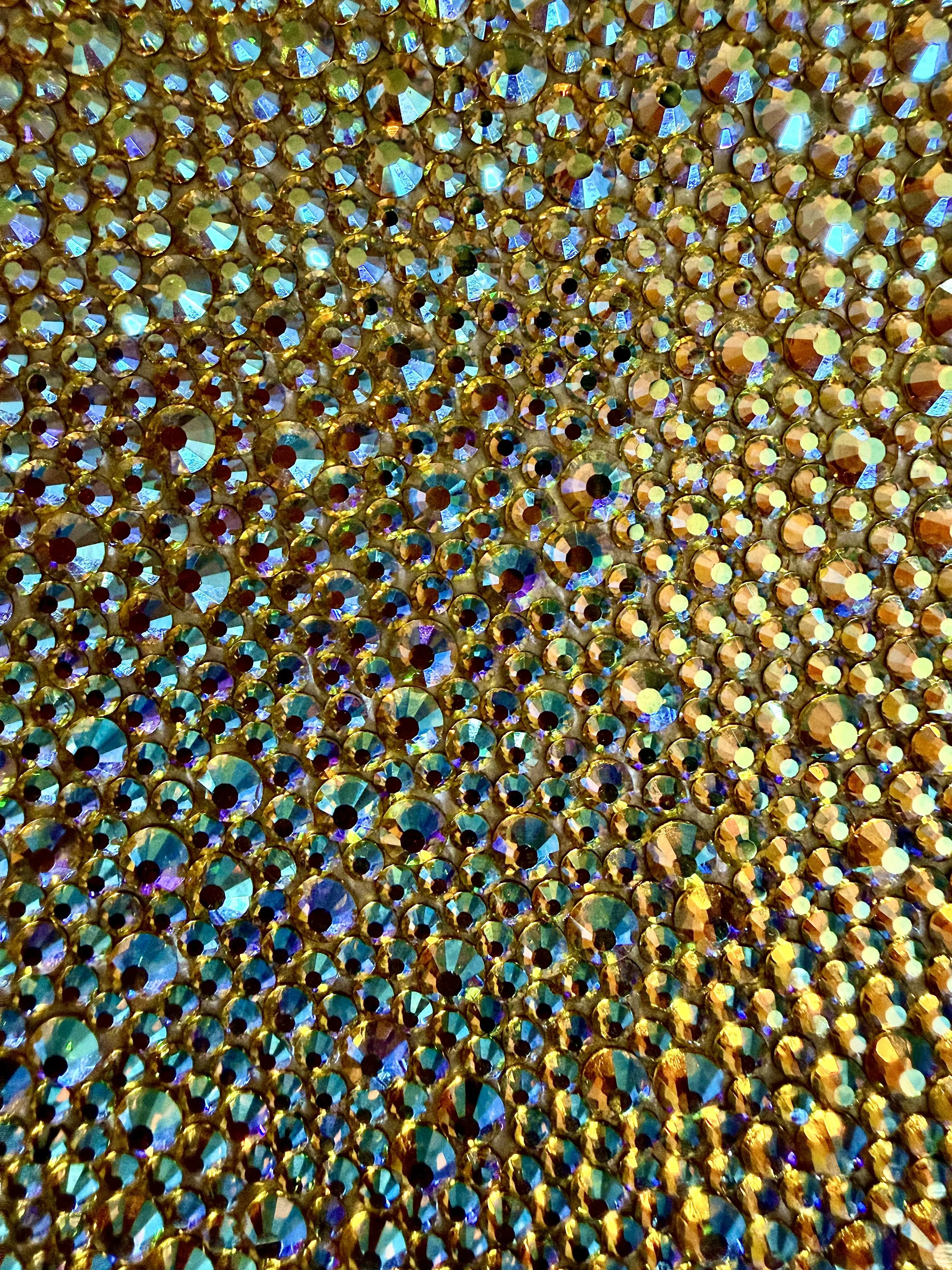 Optimism [Macro] 2025. 8 x 8 in. Close-up of gold and iridescent glass rhinestones highlighting faceted surfaces and repetitive hand-placed detail.