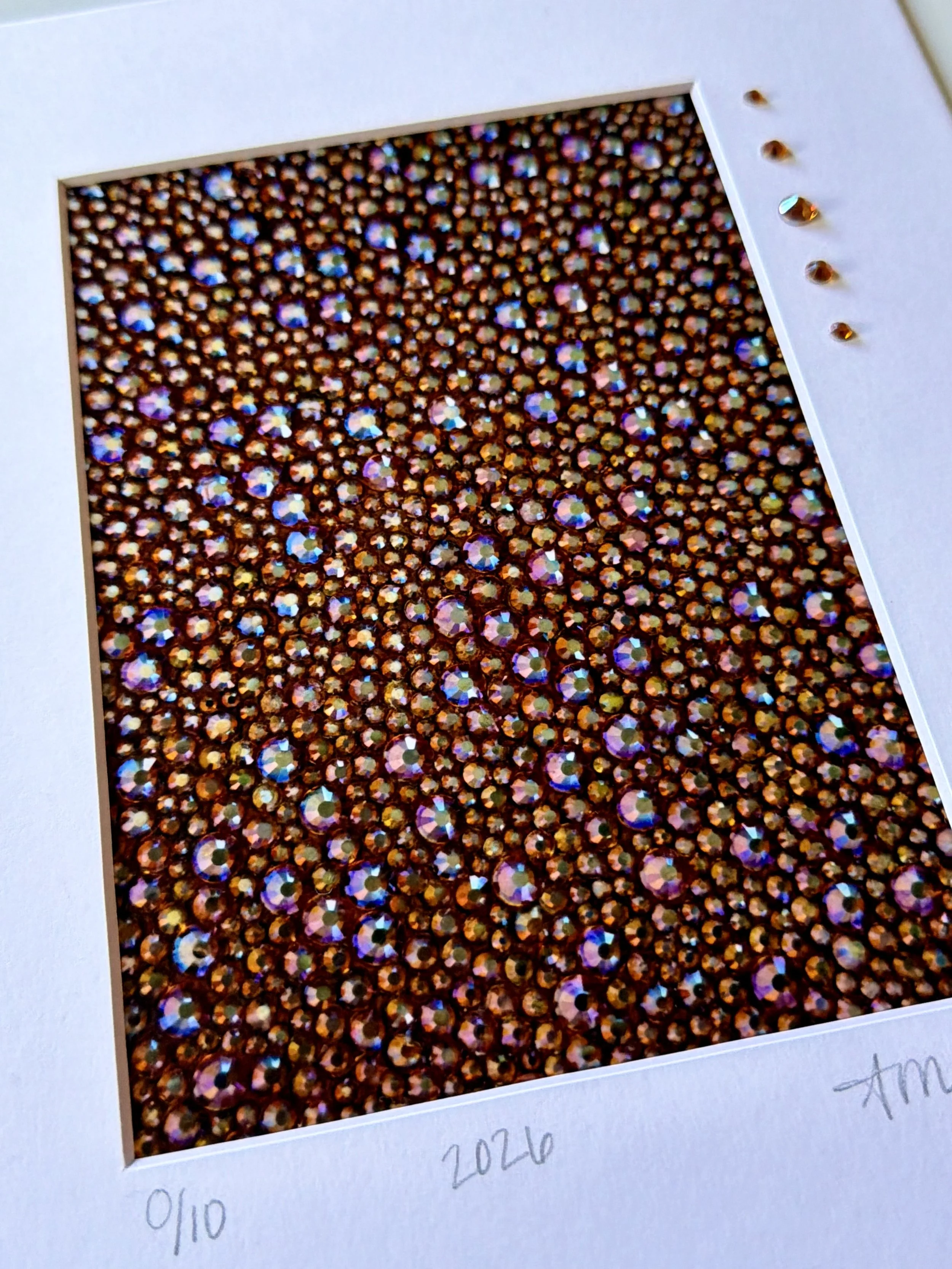Detailed macro shot of 'Gluttony' print showing the metallic paper texture and three-dimensional glass rhinestones hand-applied to the artwork surface.