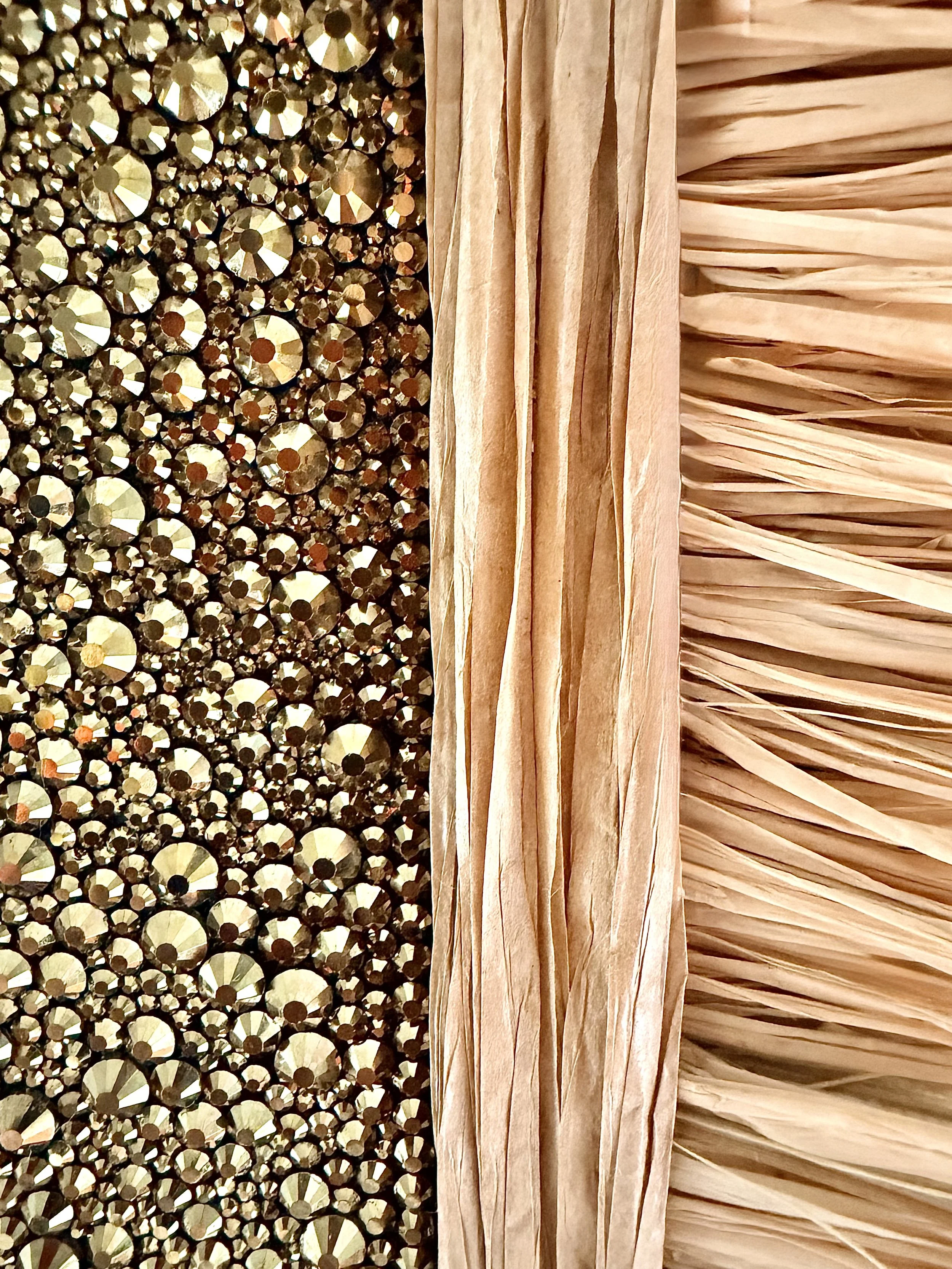 A macro close-up of the "Adrift" art piece, showcasing multi-sized gold rhinestones and textured natural raffia.
