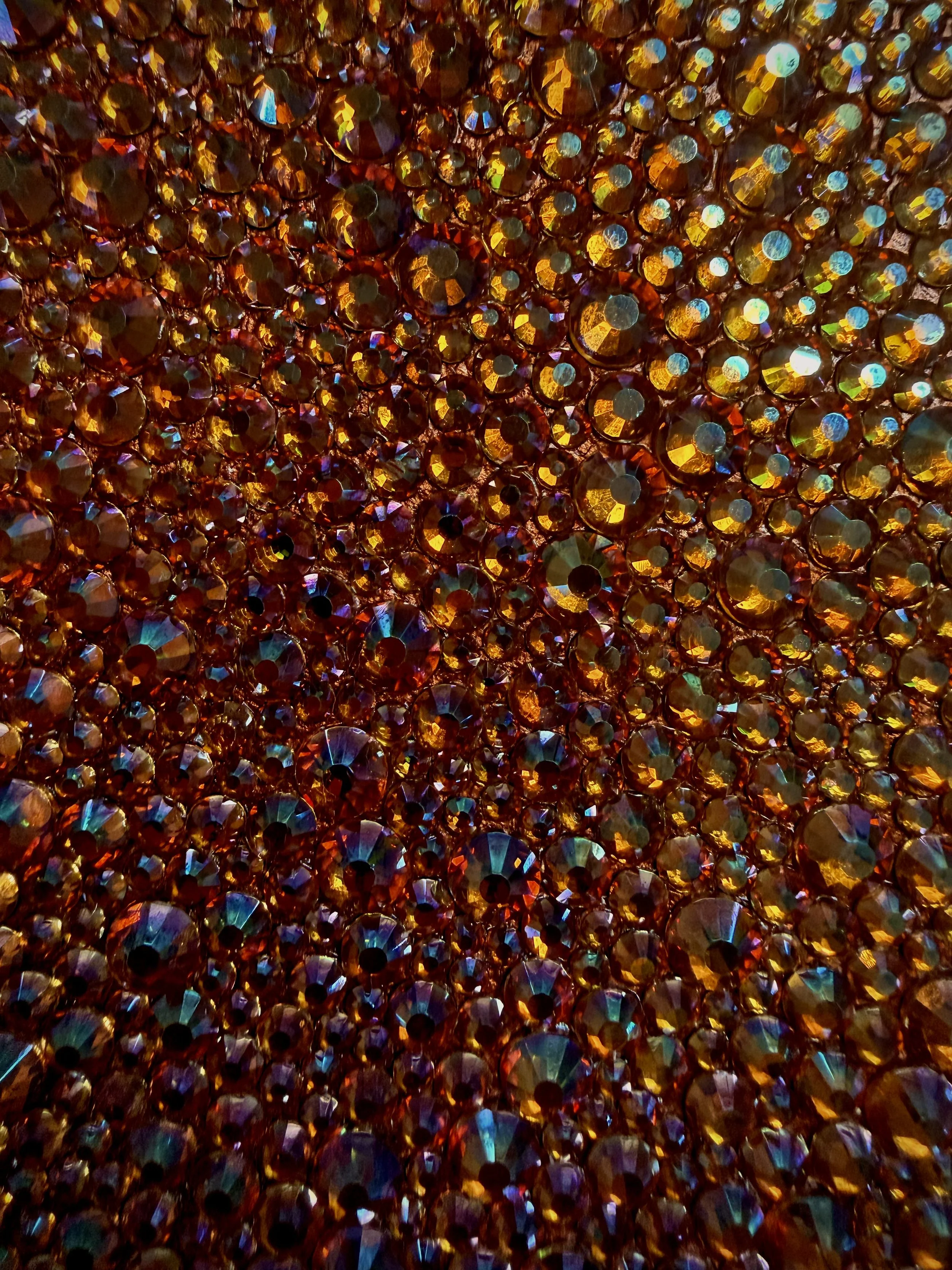 Macro detail of Gluttony (2026). Close-up of faceted amber glass rhinestones, showing the light-catching texture and dense manual placement.
