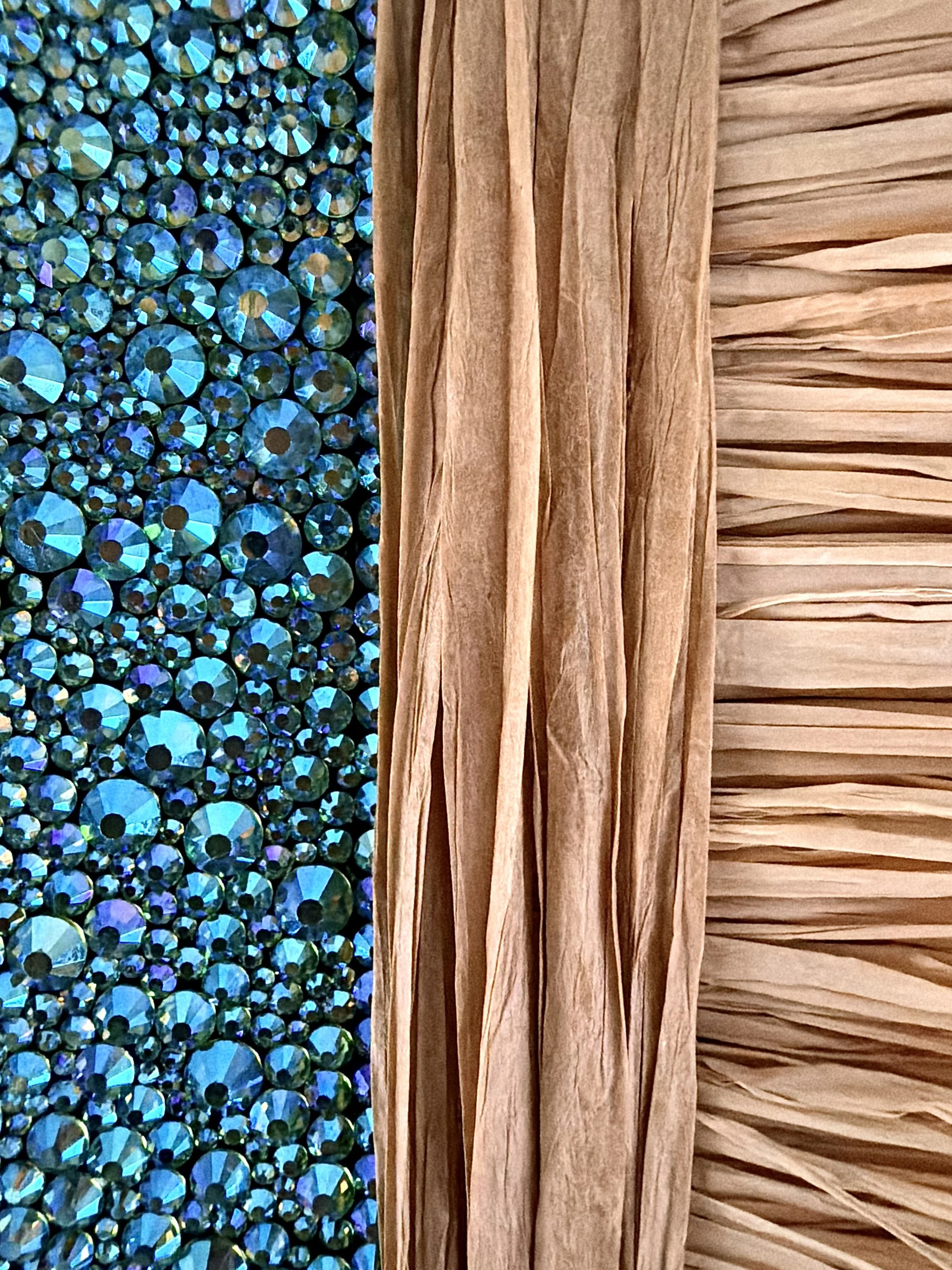 A macro close-up of the "Futile" art piece, showcasing multi-sized teal rhinestones and textured natural raffia.