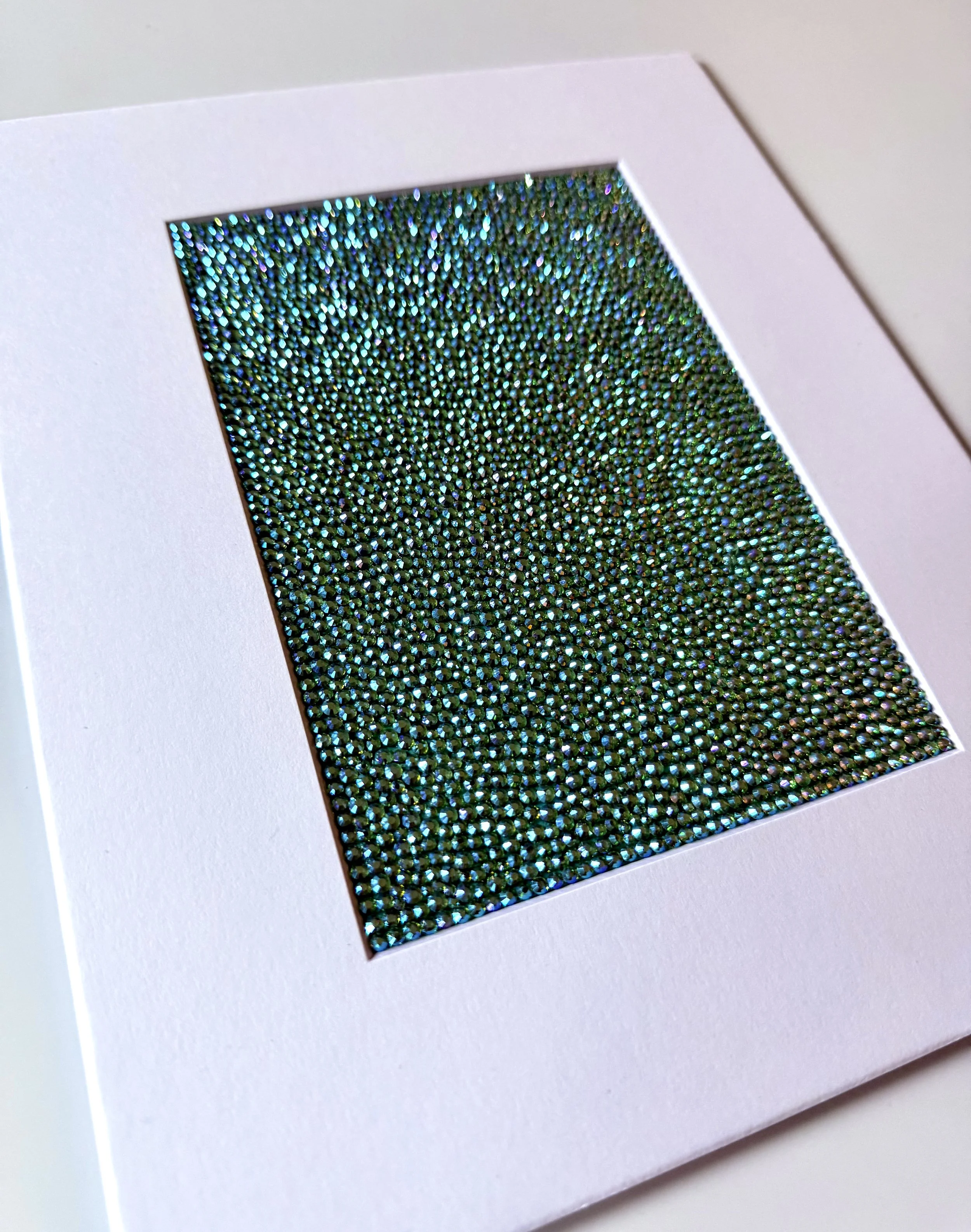 An angled close-up of the "Hollow" paper study, showing the high-relief texture of the green and gold rhinestone field.