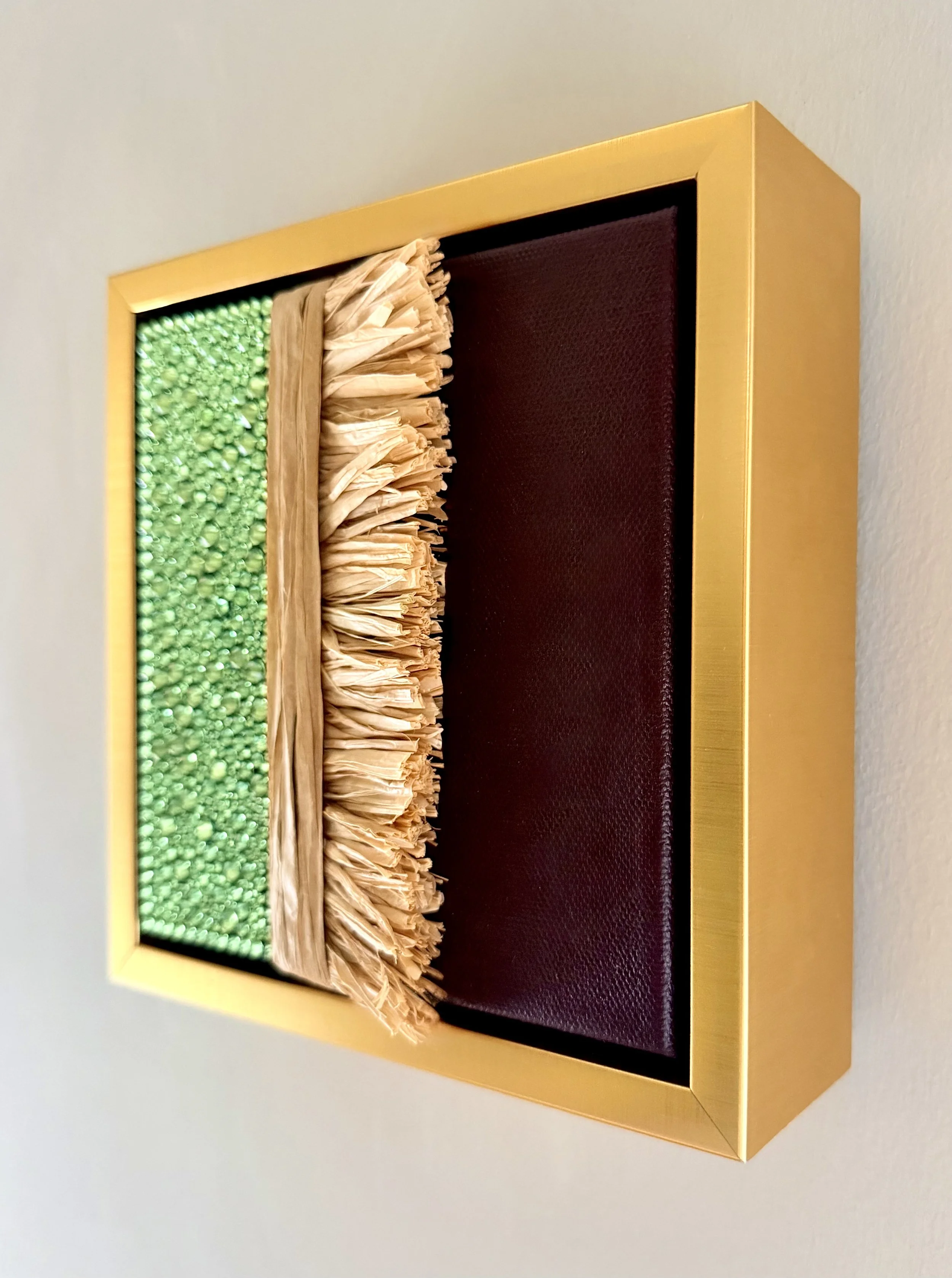 A profile image of "Dissolution" a 6x6 inch mixed-media piece of light green rhinestones and natural raffia in a brushed-gold floating frame.