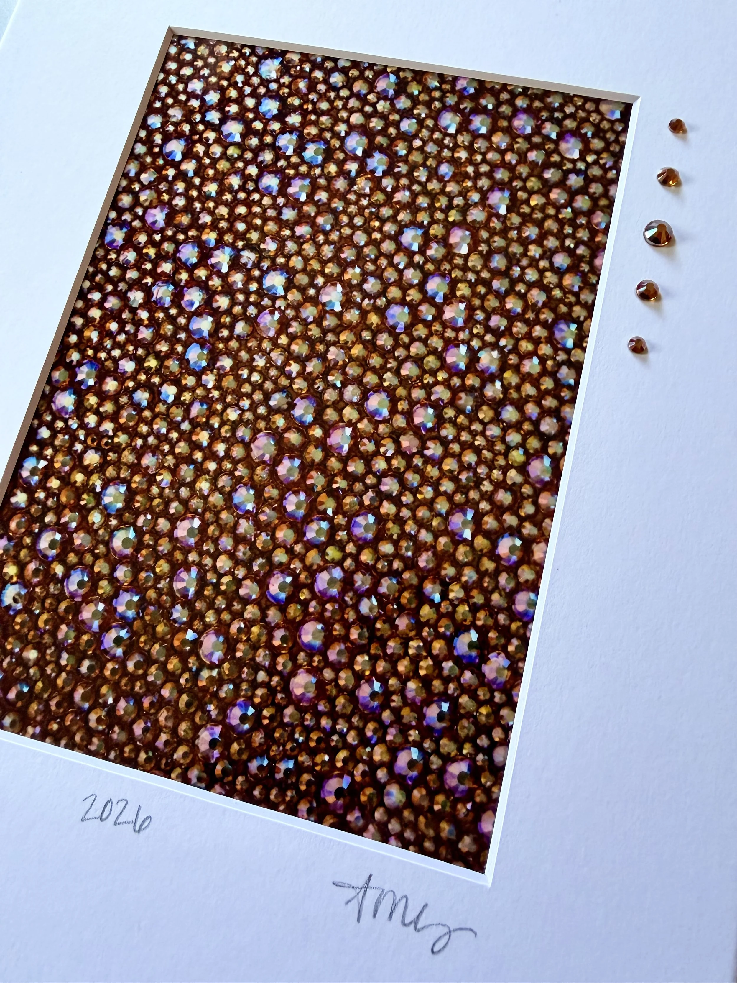 Detailed macro shot of 'Gluttony' print showing the metallic paper texture and three-dimensional glass rhinestones hand-applied to the artwork surface.