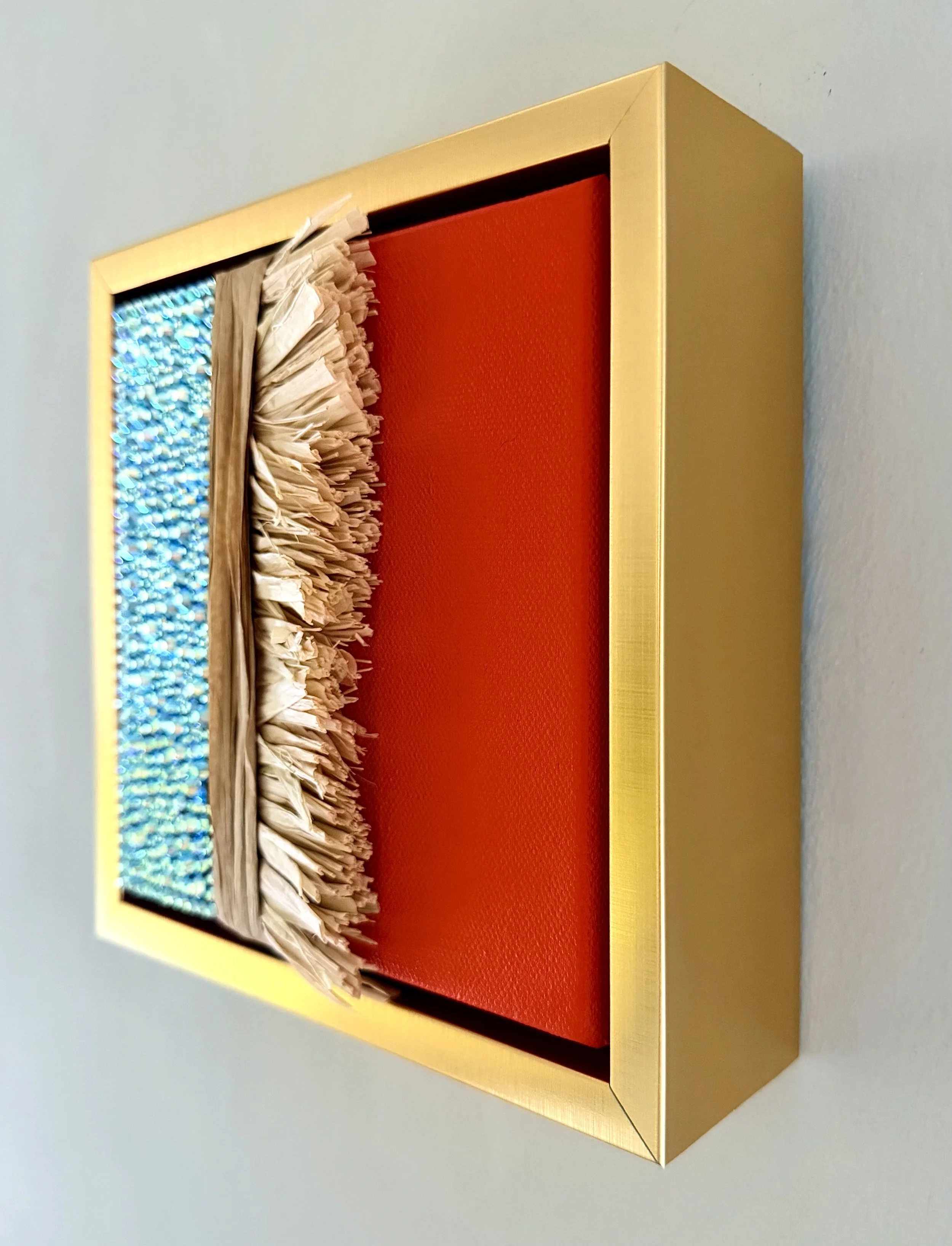 A profile image of "Entropy" a 6x6 inch mixed-media piece of aqua AB rhinestones and natural raffia in a brushed-gold floating frame.