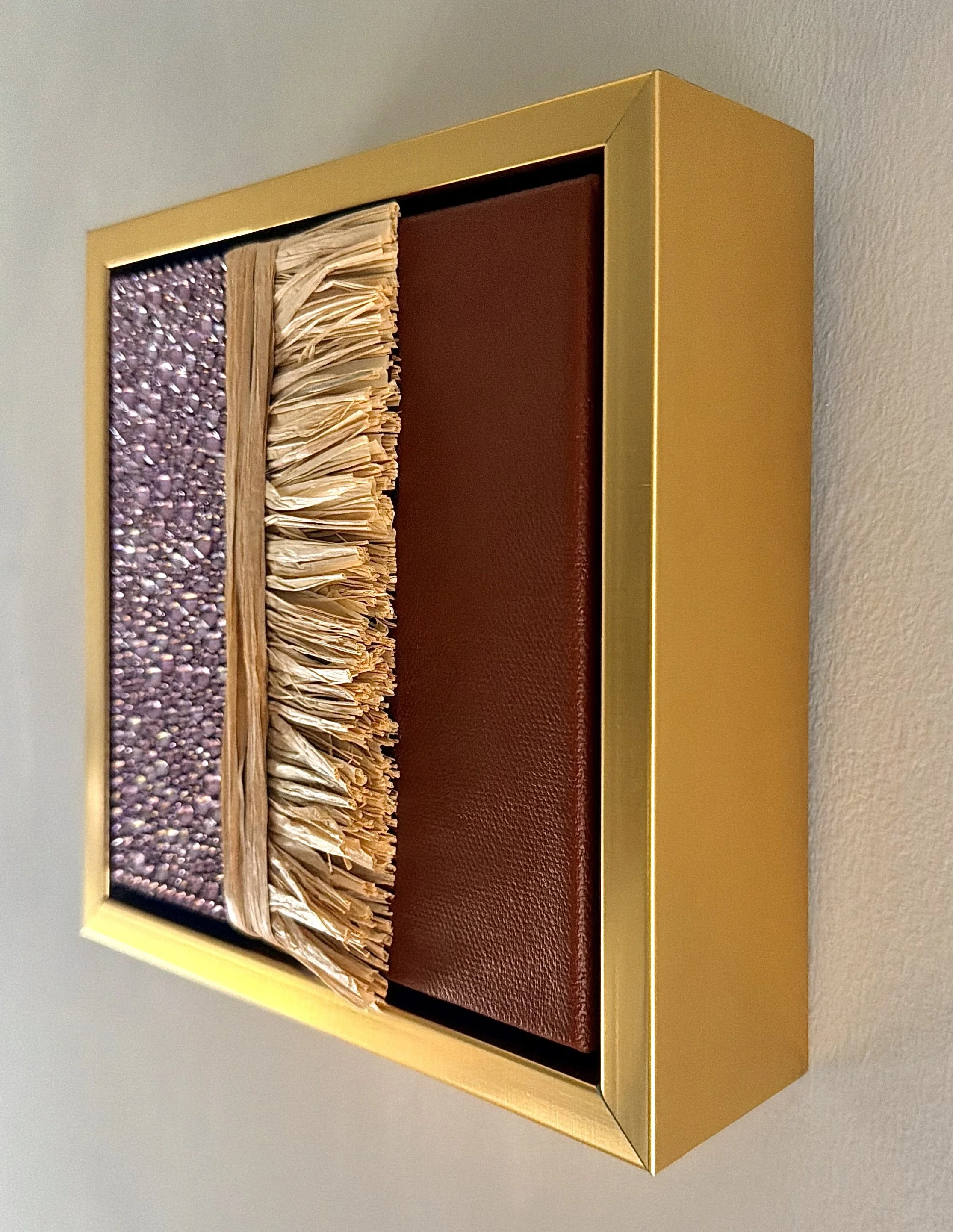 A profile image of "Collapse" a 6x6 inch mixed-media piece of mauve rhinestones and natural raffia in a brushed-gold floating frame.