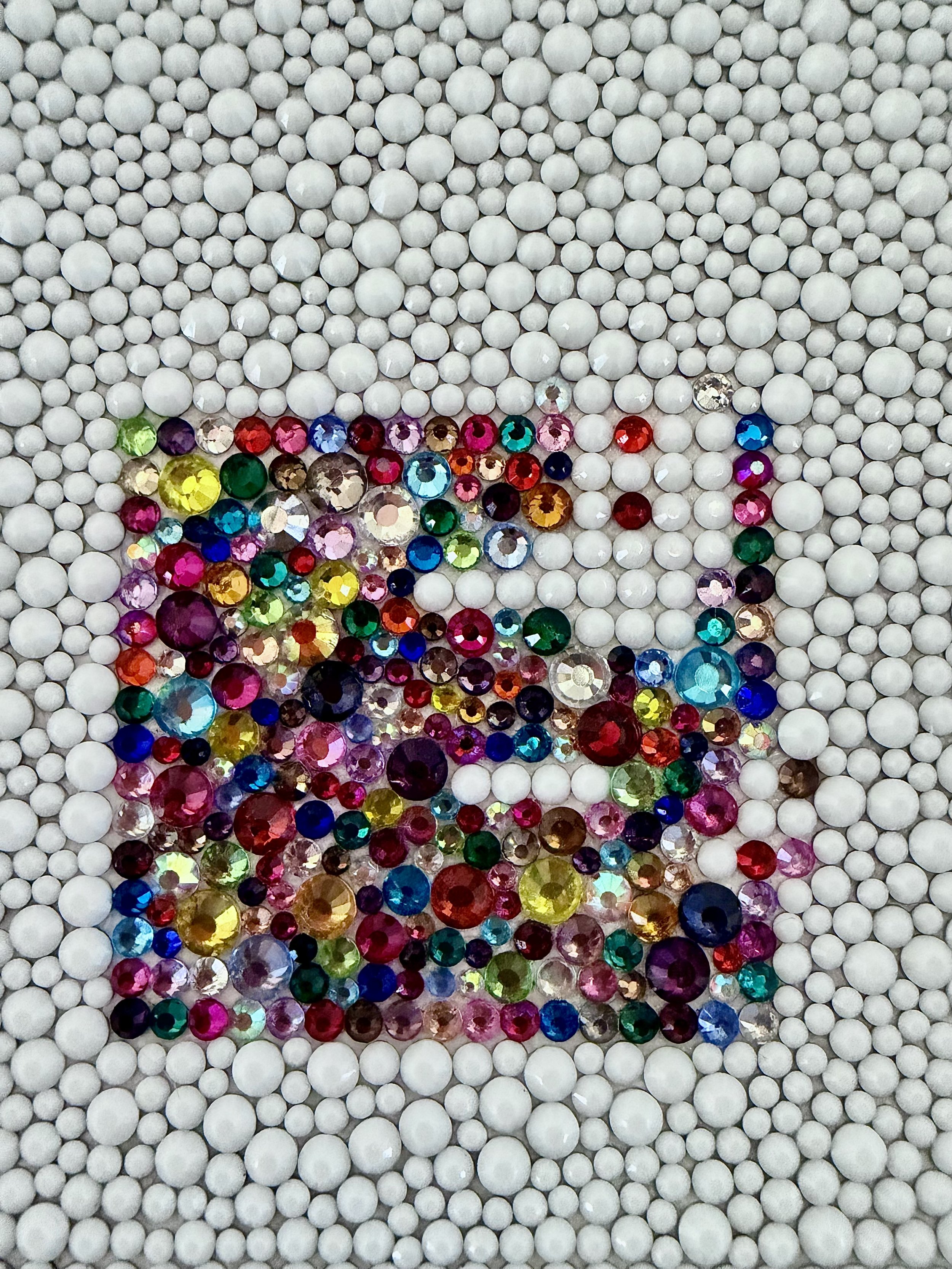 Macro close-up of "Dread," highlighting the texture of uniform white beads surrounding a square cluster of multi-colored rhinestones.